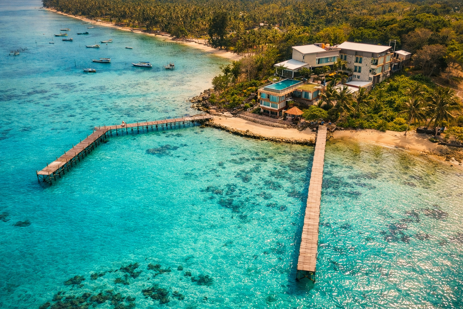 Vue aérienne d'un resort de luxe en bord de mer turquoise avec pontons en bois, hébergement tropical haut de gamme