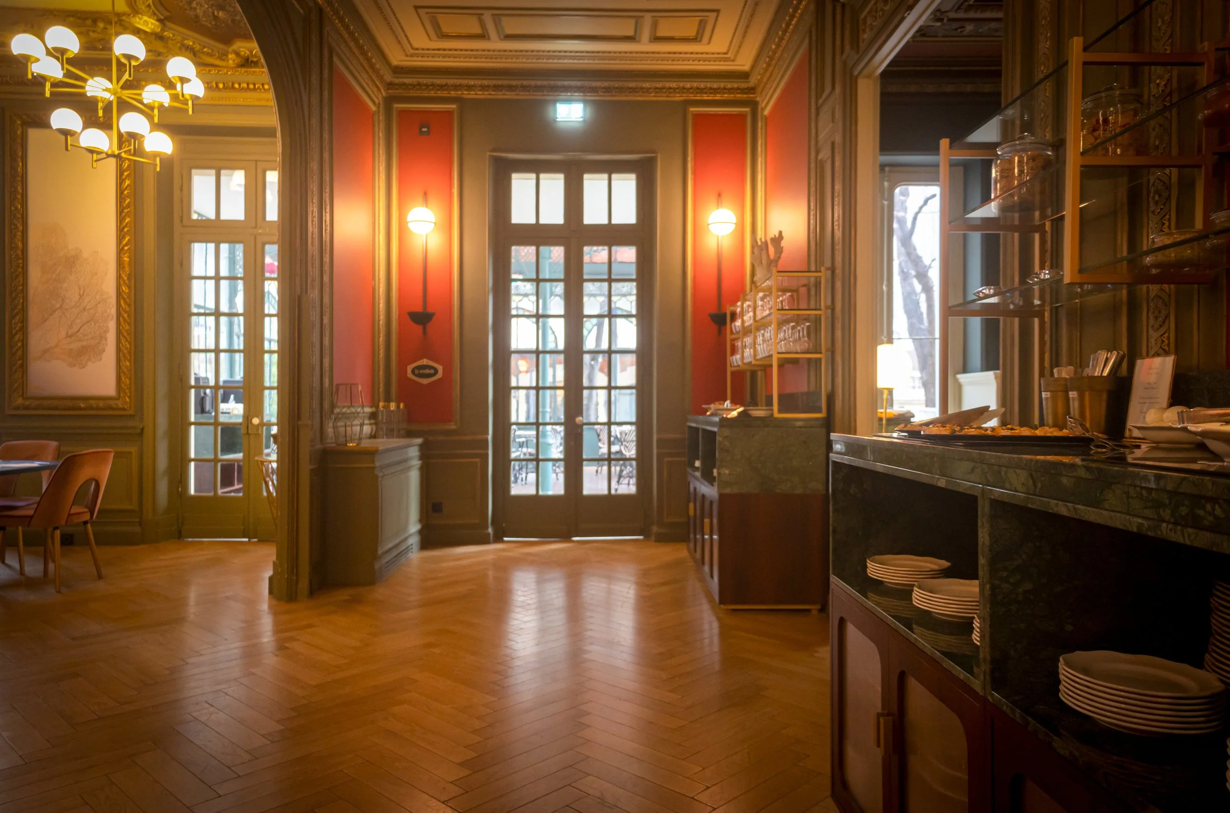 Salle de restaurant gastronomique classique avec boiseries sombres, lumières tamisées et comptoir en marbre, ambiance restaurant traditionnel français