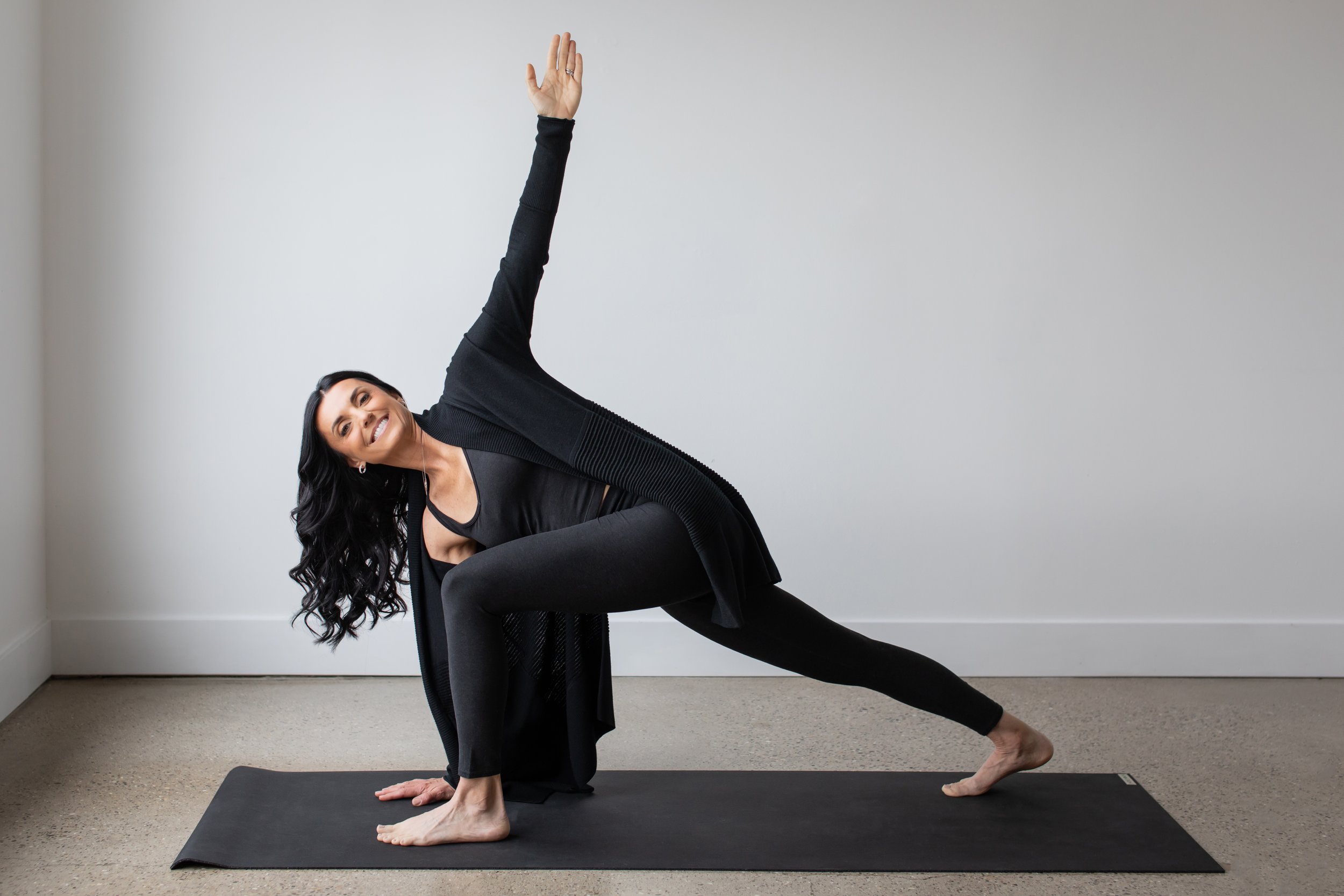 kathleen belonga, a yoga therapist, in vuori pants, vuori tank top, demonstrating low-lunge a yoga pose