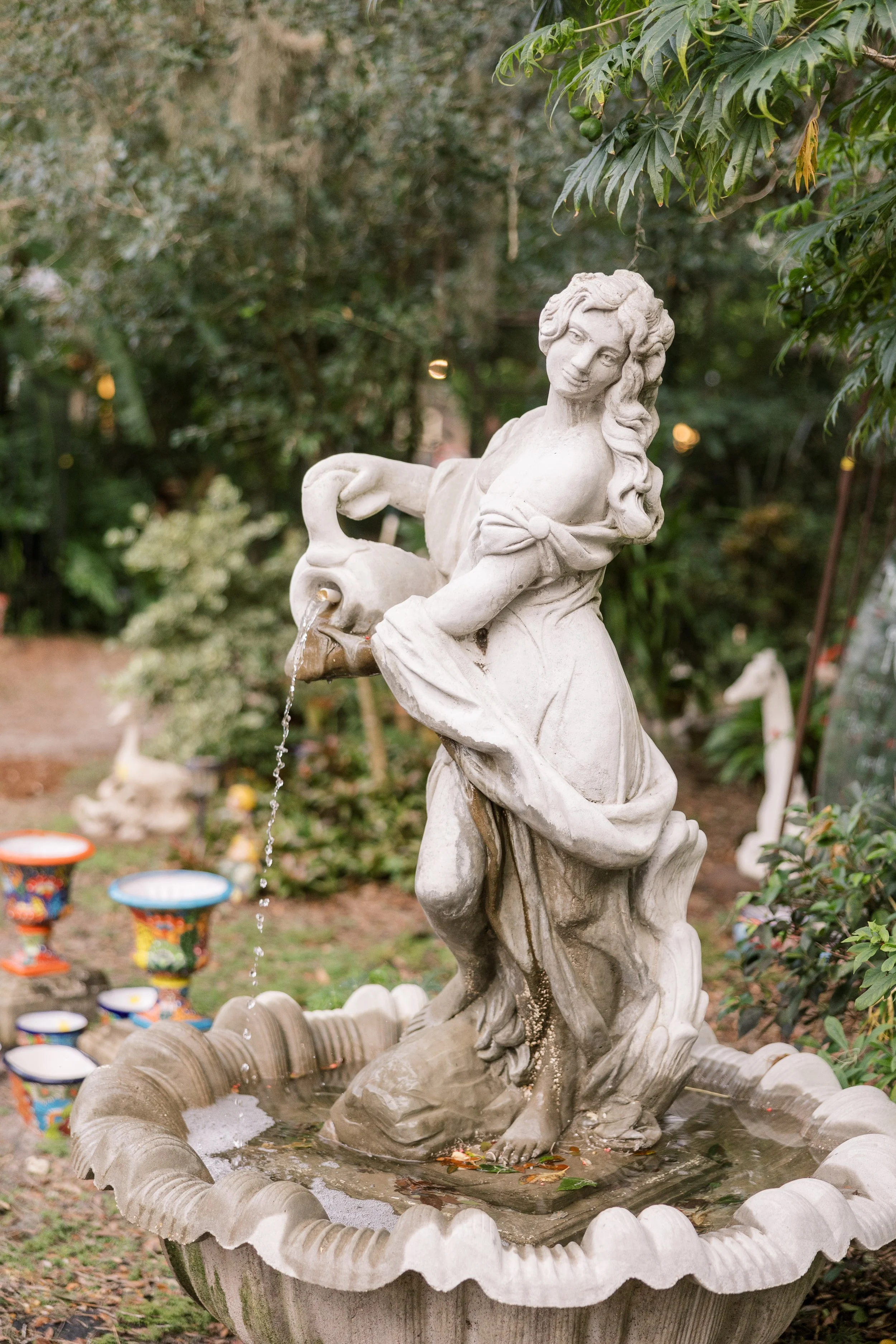 Whimsical wedding signage displayed among greenery in an enchanted garden