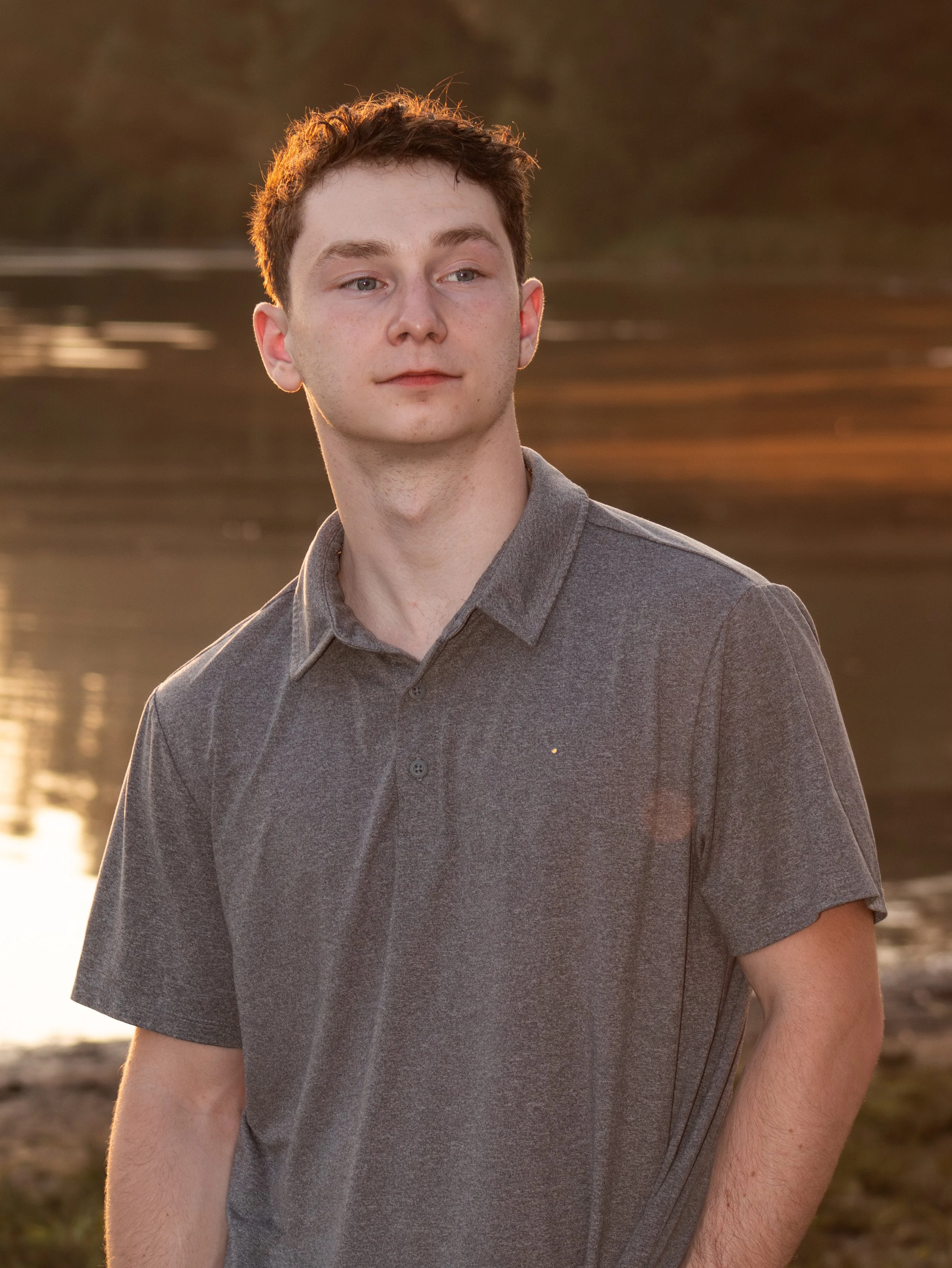 Young man posing for senior photos at Hopedale Pond in Hopedale, MA.