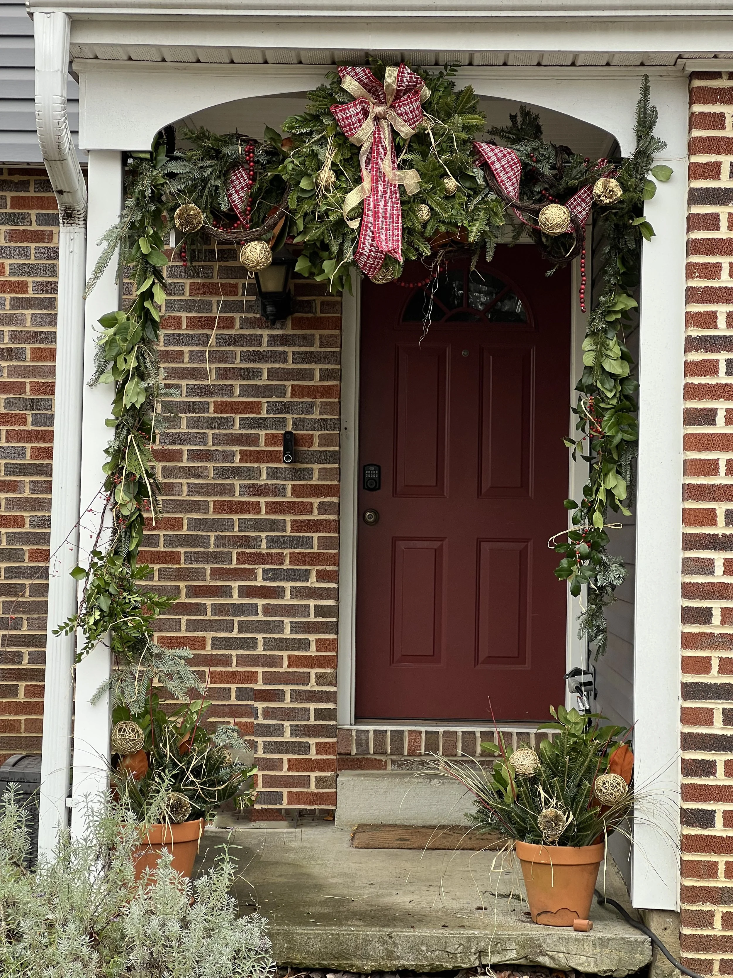 Front door decorated with Christmas greenery, ribbon, and ornaments. Severna Park, MD