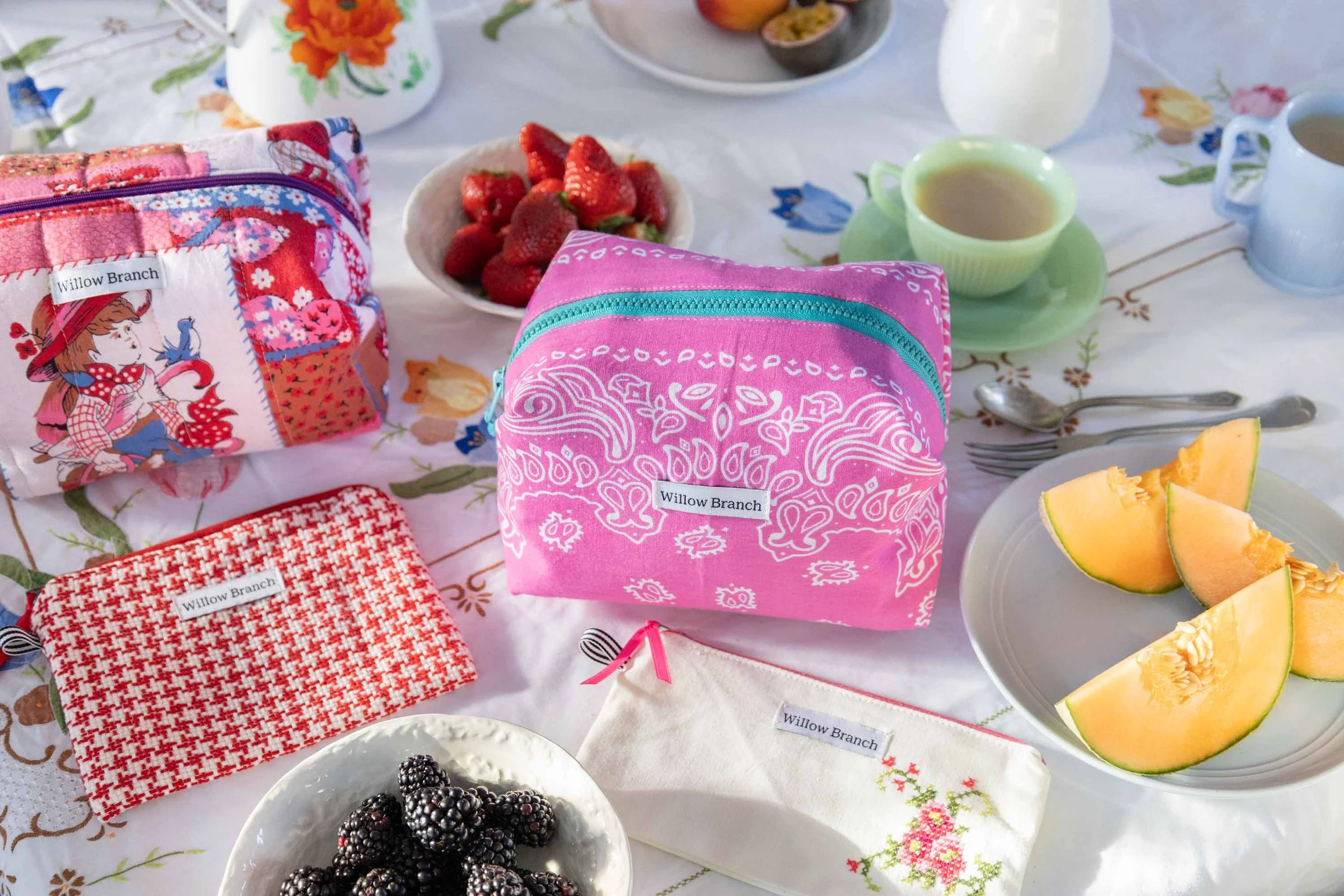 Table scape of Willow Branch flat pouches and makeup bags using upcycled vintage fabrics for the new launch of items for 2026