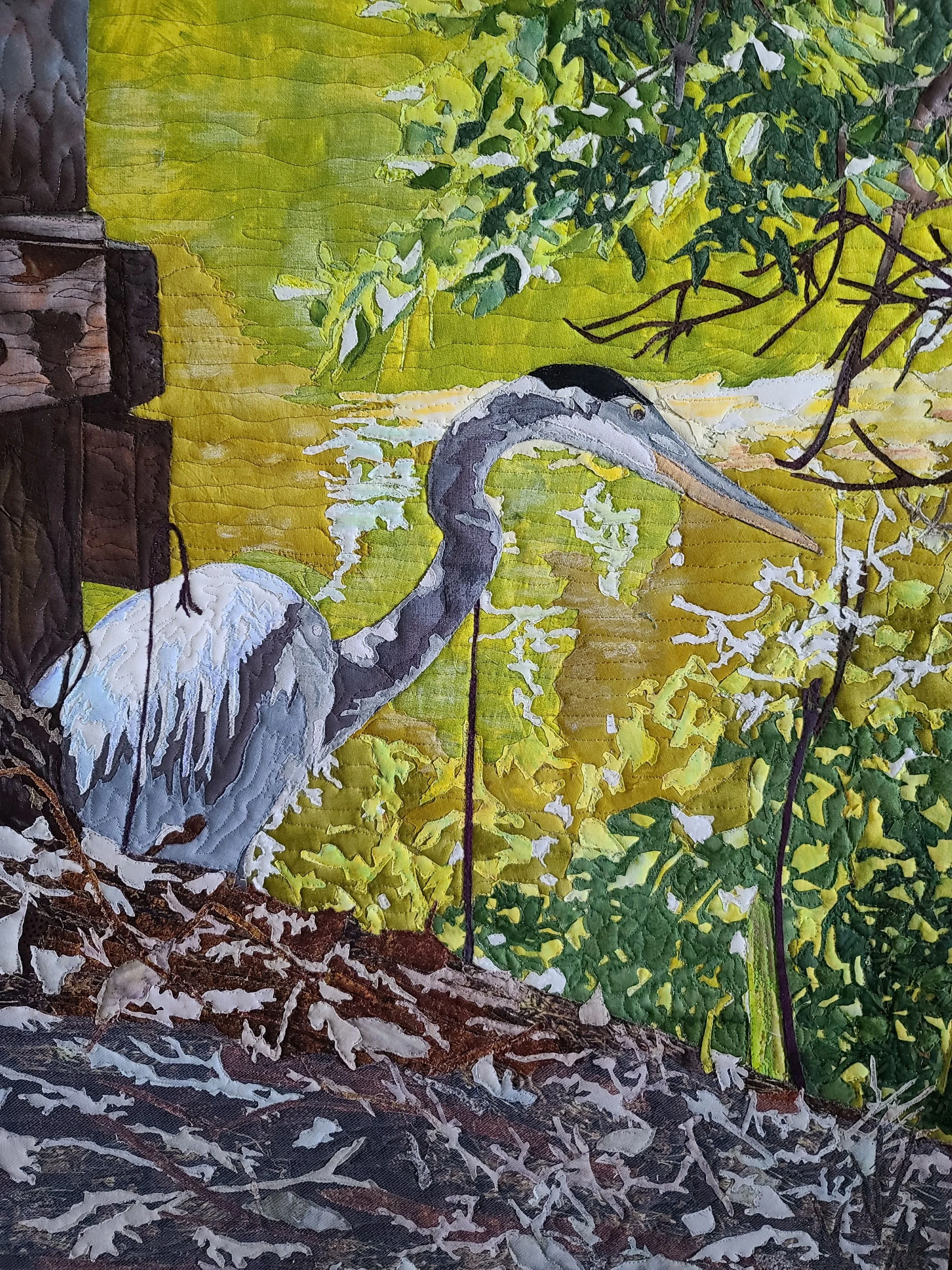 A painted fabric depicting a heron standing on a log near water with lush green foliage in the background.