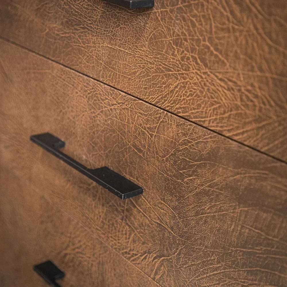 Close-up of a wooden dresser with textured brown surface and black handles.