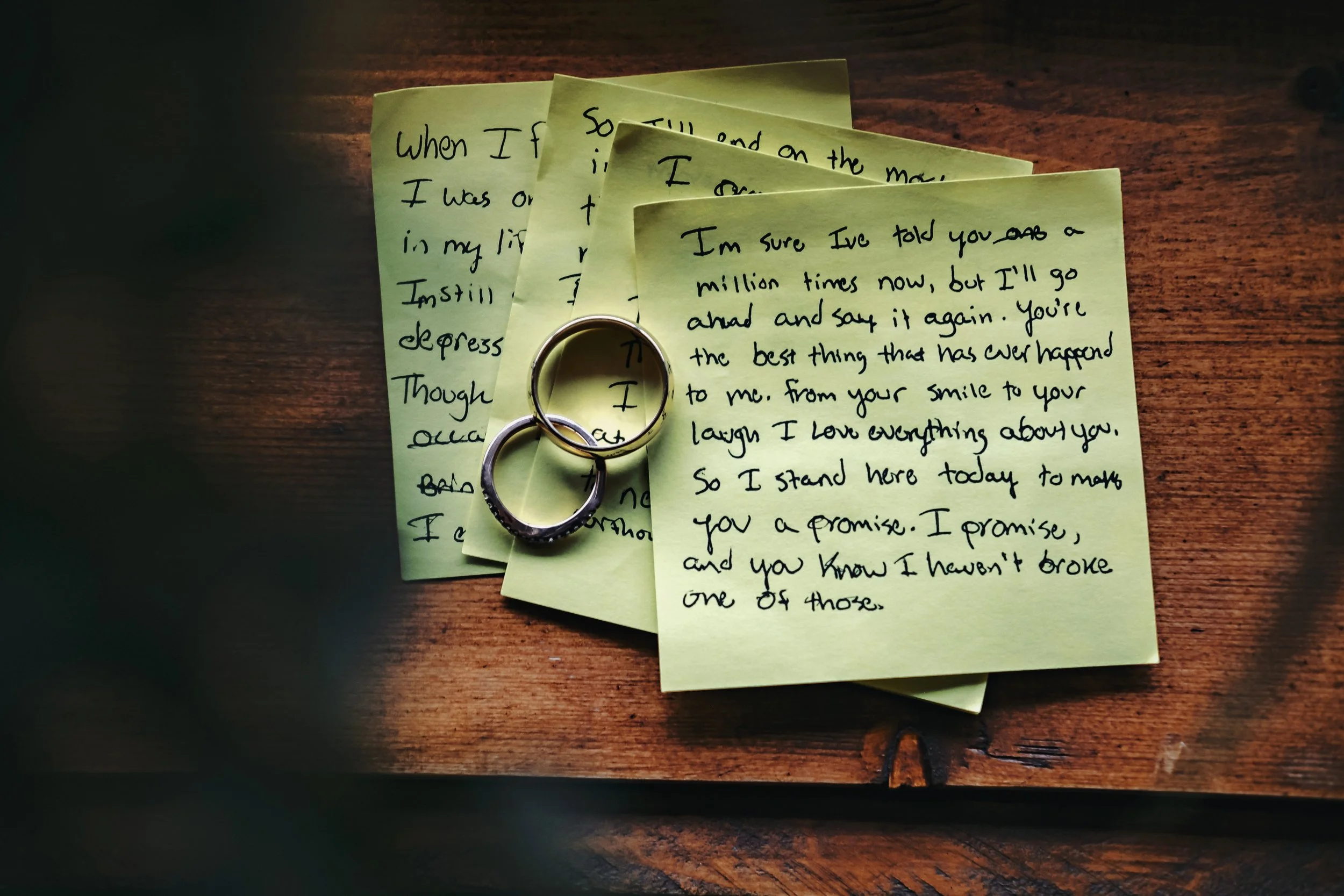 Two wedding rings resting on a bouquet of pink and white flowers.