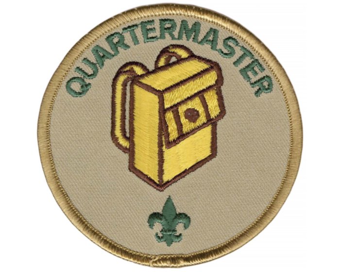 A circular cloth patch with the text 'Quartermaster' at the top, an embroidered yellow backpack in the center, and a green fleur-de-lis symbol at the bottom.