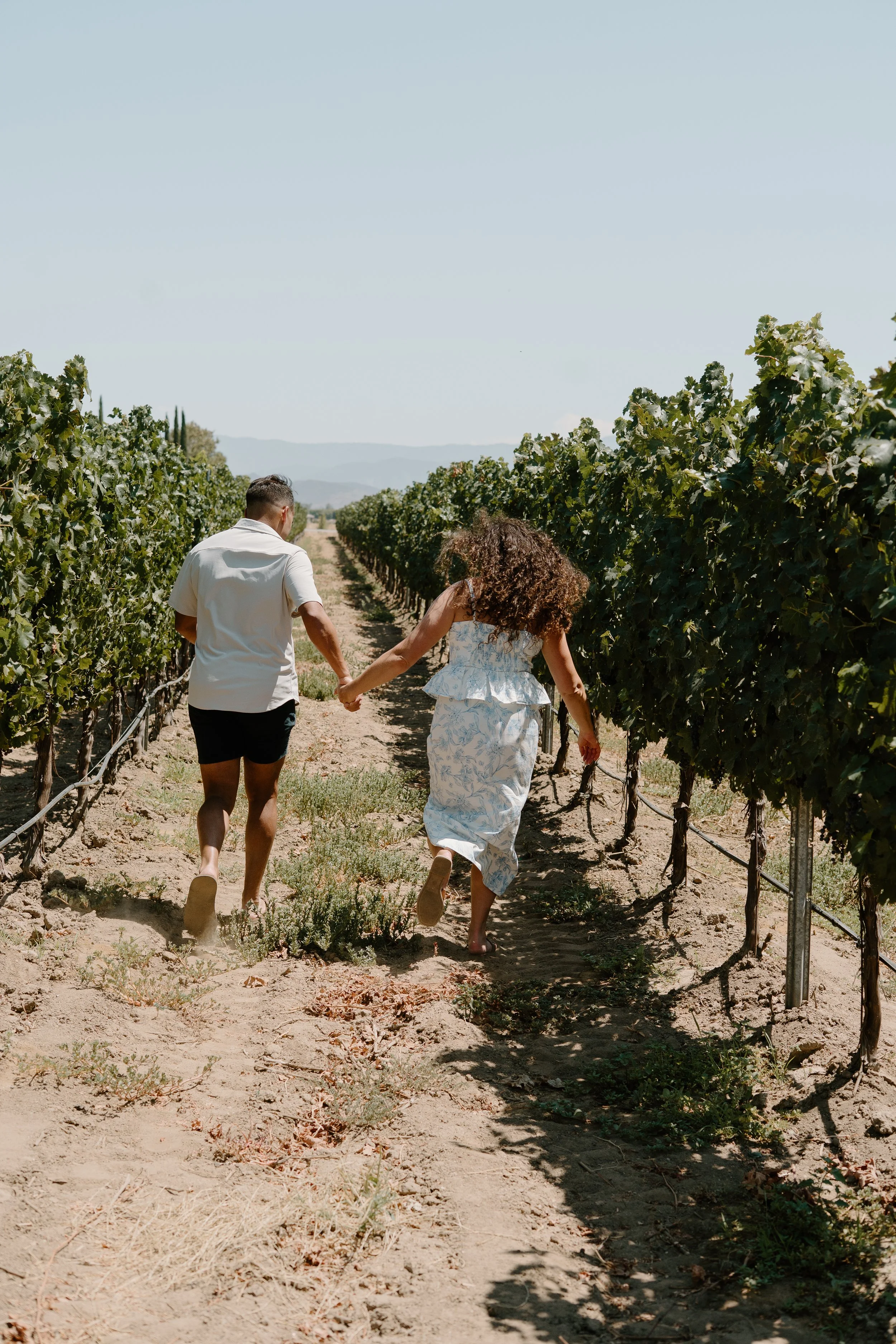 proposal-couple-running-through-vineyard.jpg