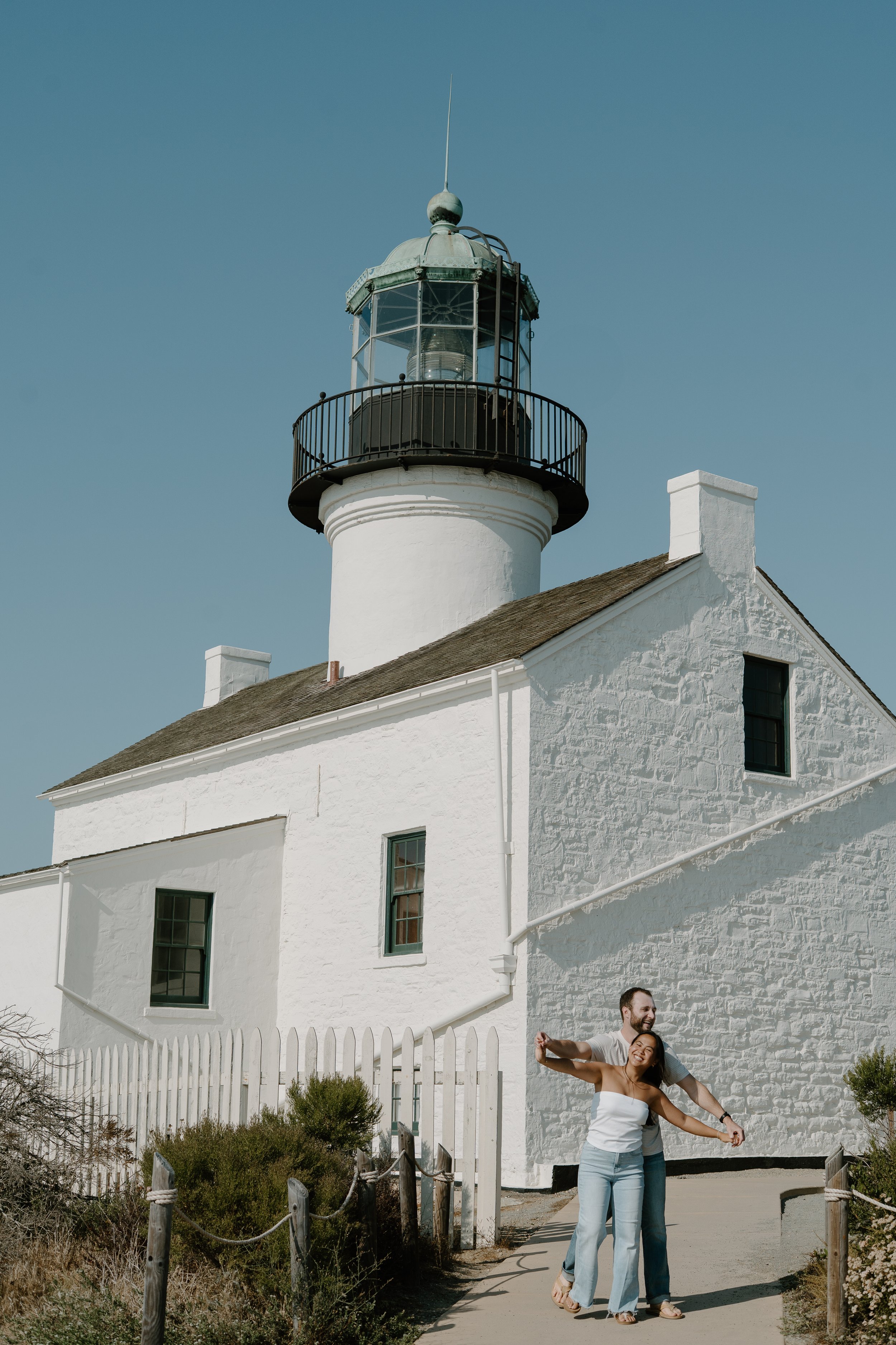engaged-couple-dancing-la-jolla-light-house.jpg