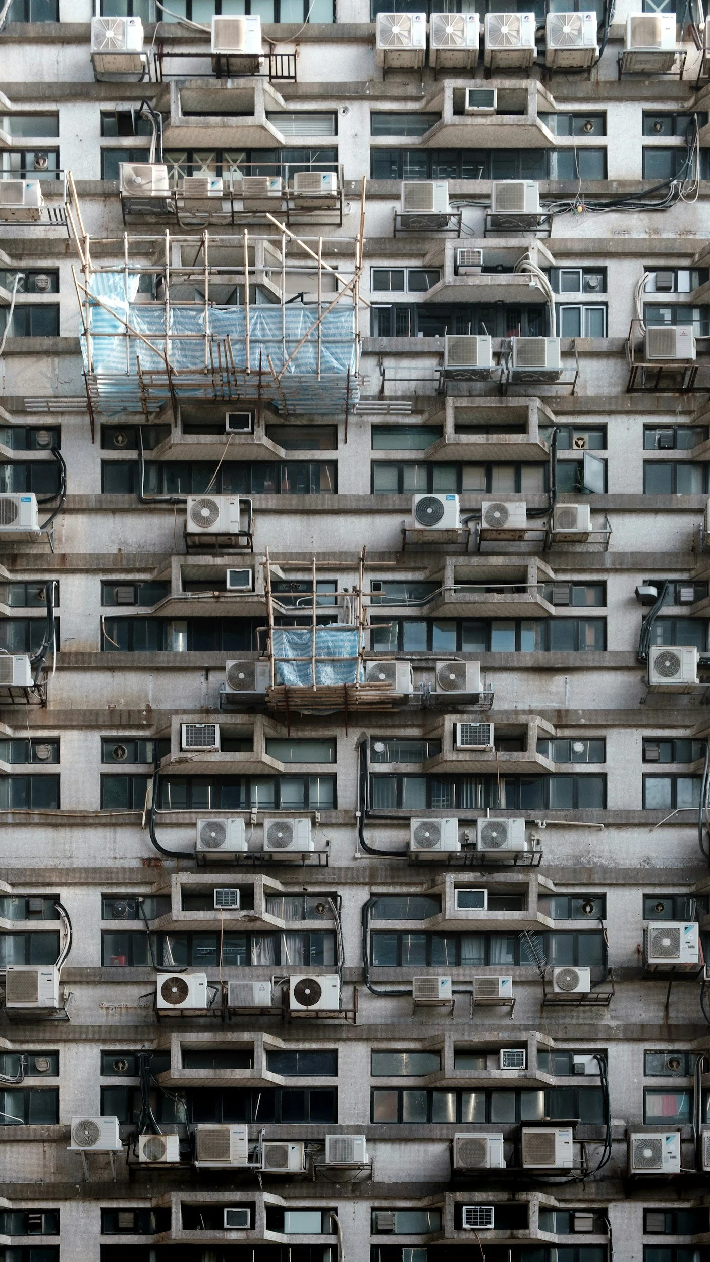 Uitzicht op de gevel van een te renoveren appartementencomplex, waarvoor een aannemer zal moeten gezocht worden. Iconic Real Estate is een ontwikkelaar die renovatieprojecten zoekt en renoveert volgens de regels van de kunst. 