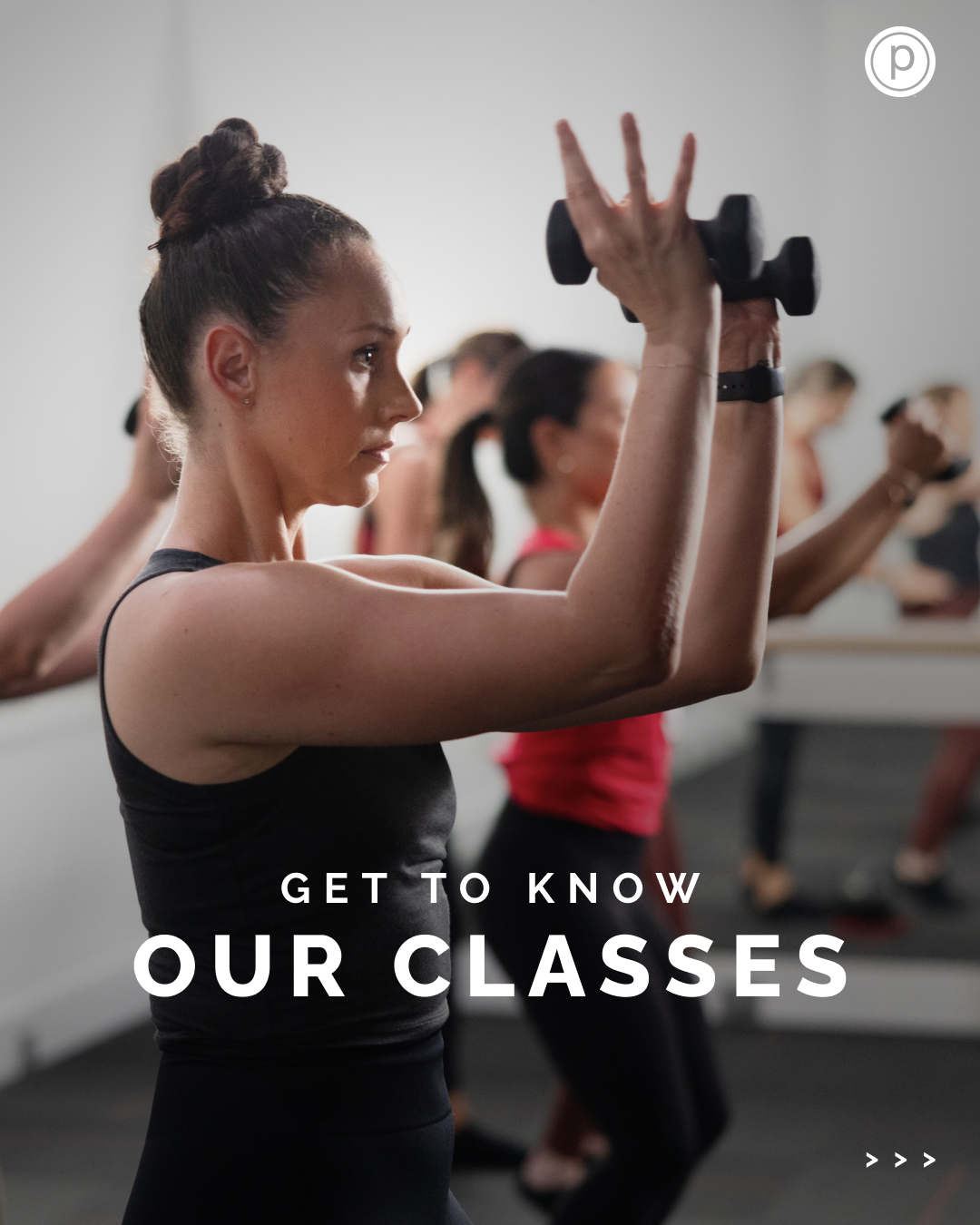 Fitness class with women lifting dumbbells in a studio, woman in foreground with bun hairstyle and black workout tank top, text overlay "Get to Know Our Classes".