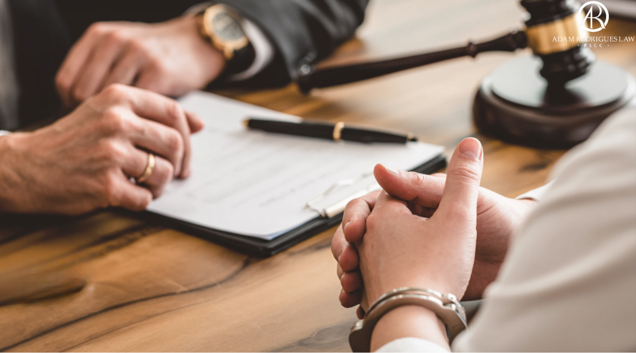 Defendant in handcuffs consulting with a criminal appeals attorney, Adam Rodrigues Law, at a desk with a gavel, representing Tennessee sentencing appeals and sentence reduction"