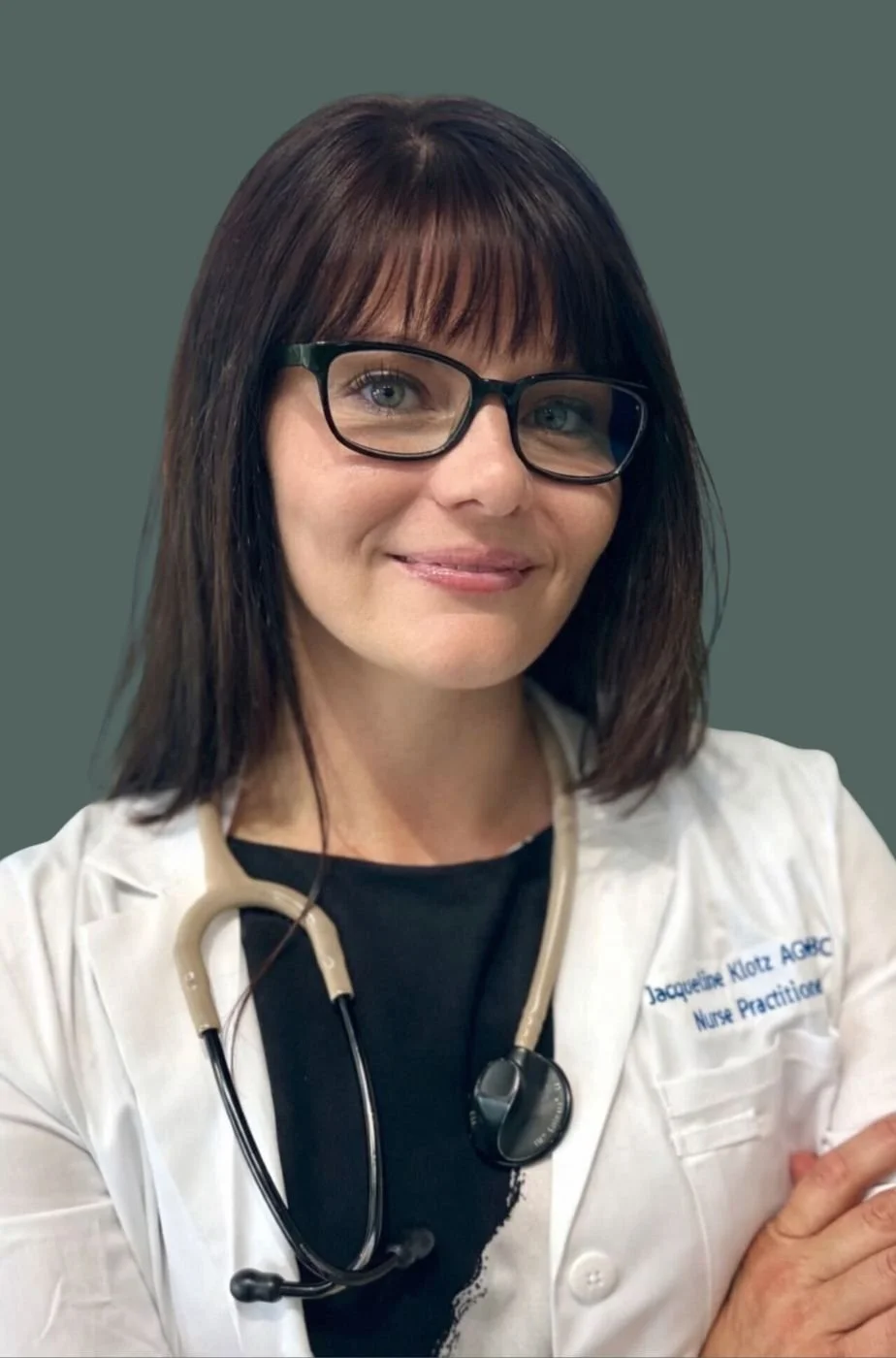 Jacqueline Klotz, AGNP-BC, board-certified nurse practitioner and founder of Alkemi Functional Wellness, wearing a white lab coat and stethoscope