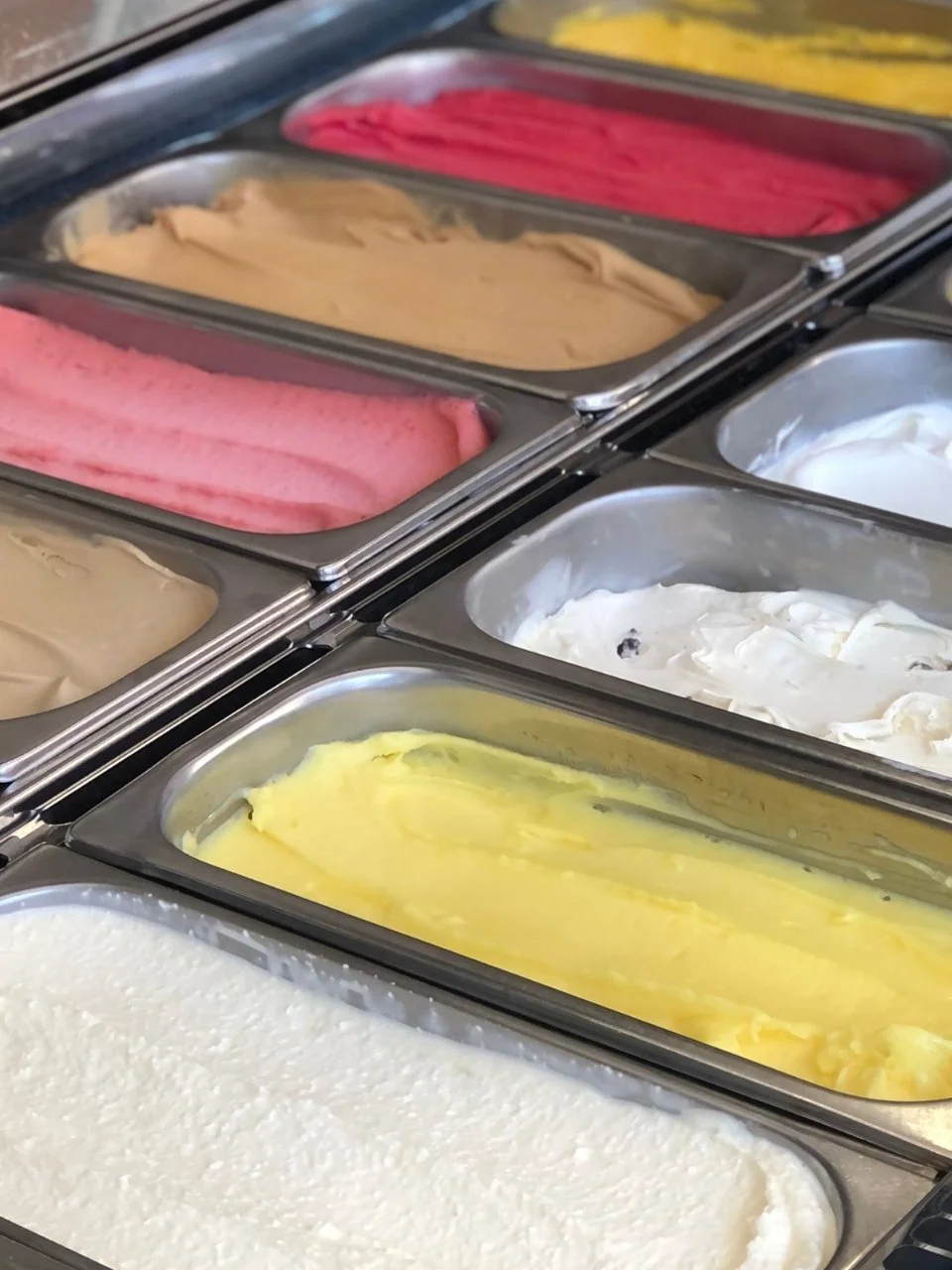 Différents parfums de glace en coupes dans un distributeur de crème glacée.