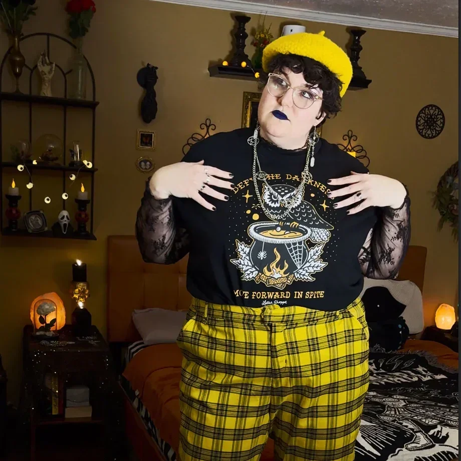 Ashabi Owagboriaye waves an asexual pride flag above their head while marching in the 2019 Chicago Pride parade