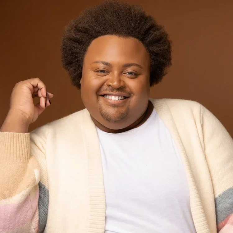 Doctor Jon Paul Higgins in a dashing cream cardigan, smiling into the camera.