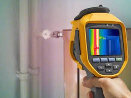 Person using a handheld infrared camera to inspect plumbing pipe with a leak.