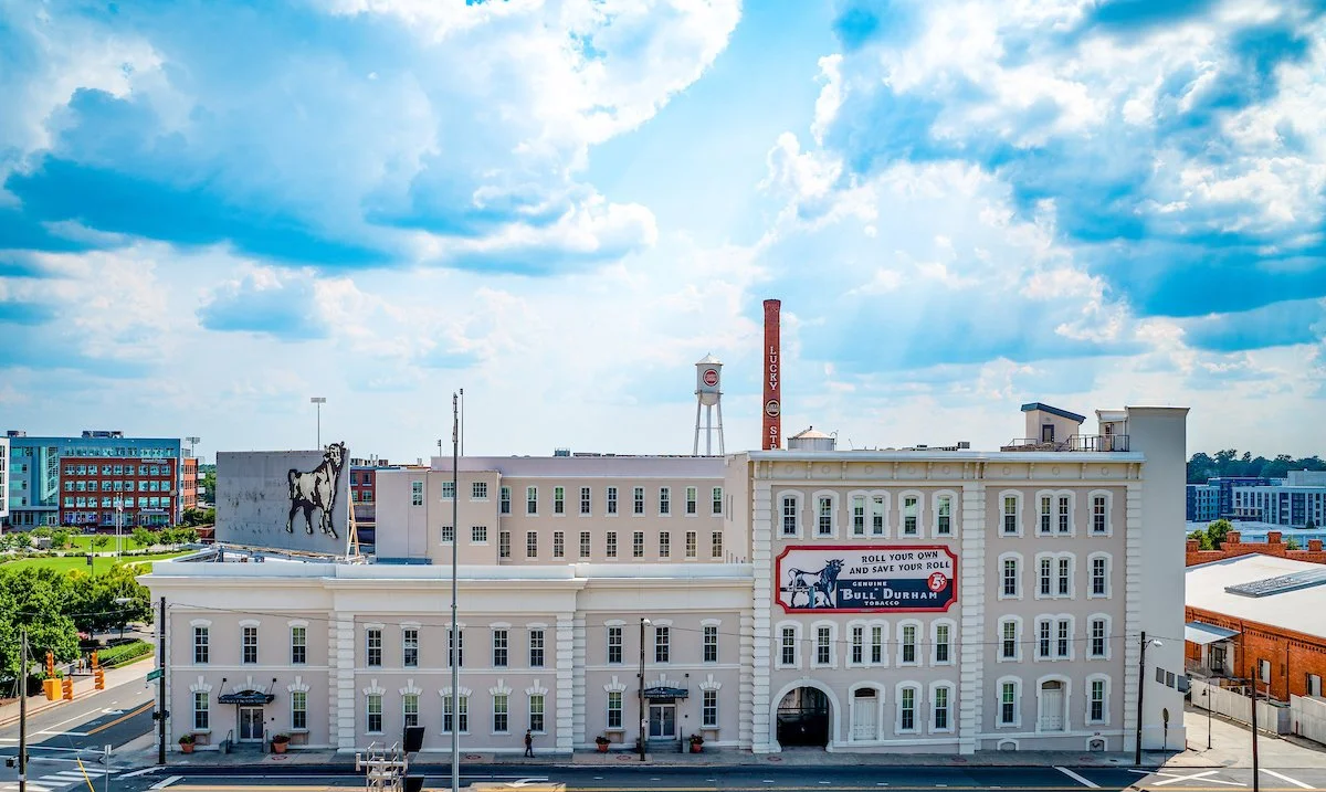 The Old Bull Building at American Tobacco Campus (ATC). The Lucky Strike smokestack and water tower are visible on the horizon