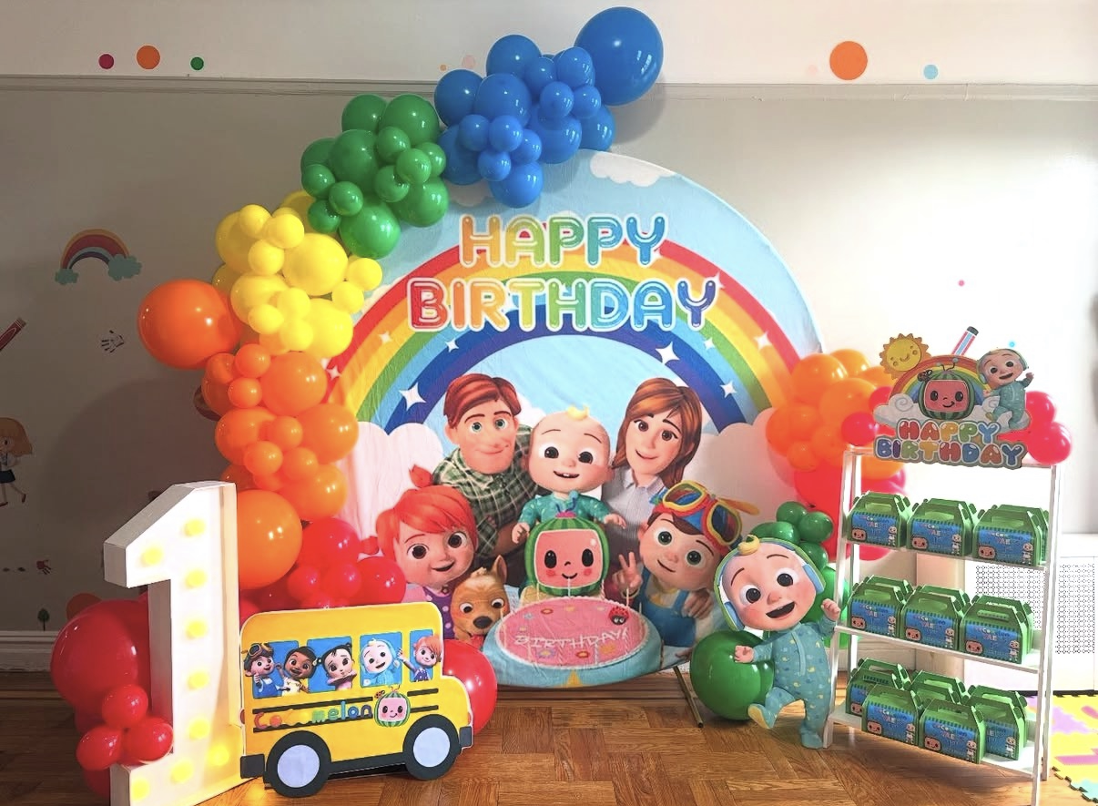 Colorful children's birthday party setup with Characters from Bubble Guppies, decorated with balloons, rainbow backdrop, and themed cake and decorations.