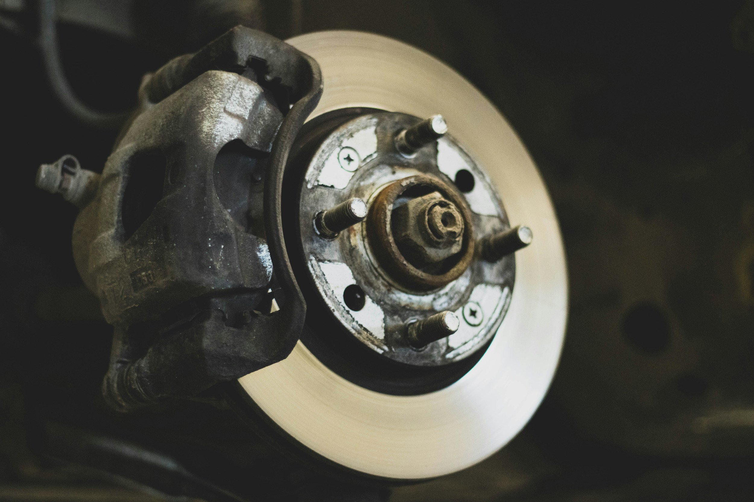 Close-up of a car brake disc, caliper, and wheel hub assembly.