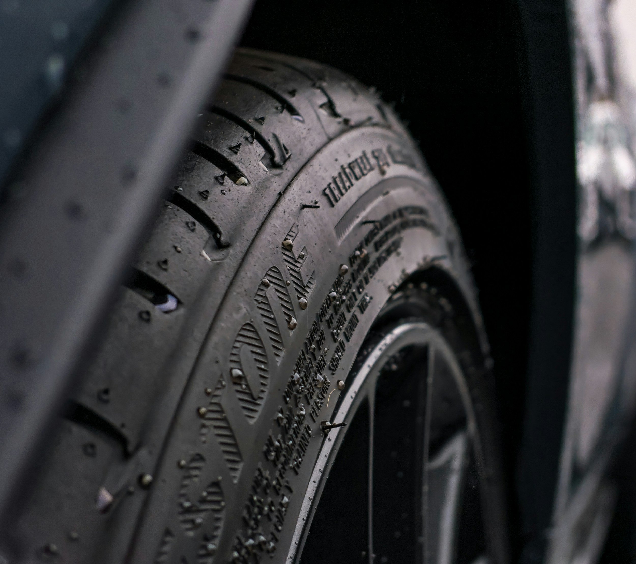 Close-up of a car tire showing tread pattern and sidewall details