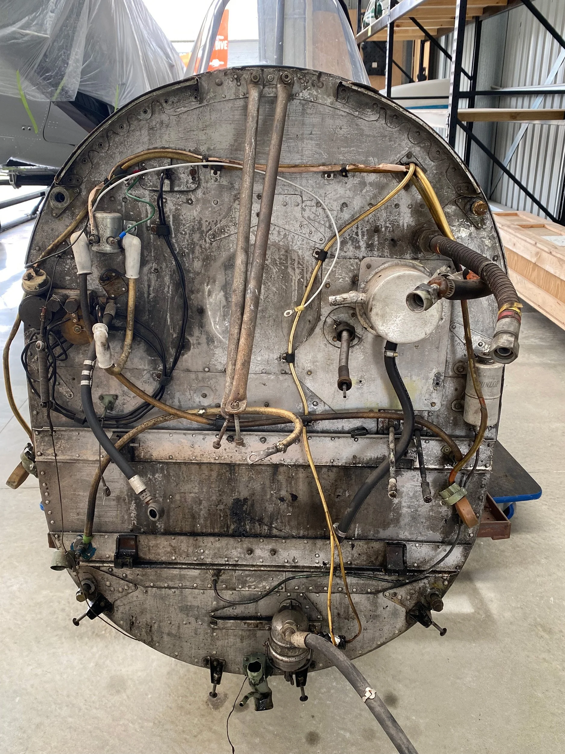Forward firewall before restoration. The circular silver component wasn't original so was removed and an ignition suppressor installed in its place.