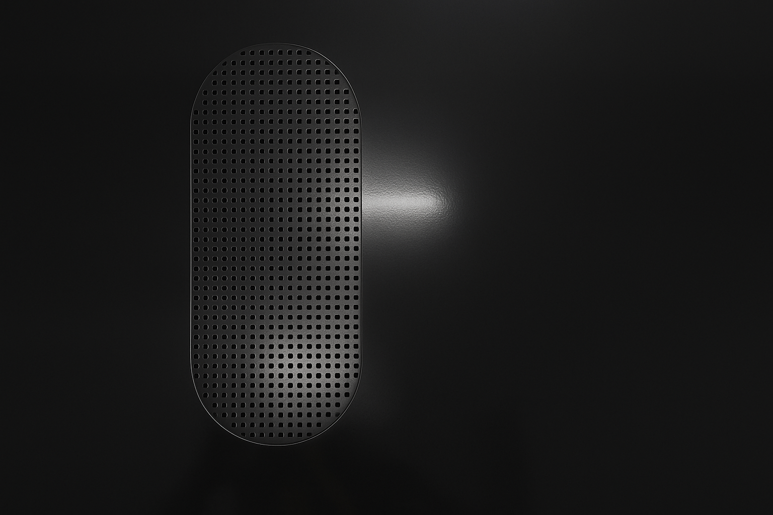 A black wireless speaker with a perforated grille on a dark background.
