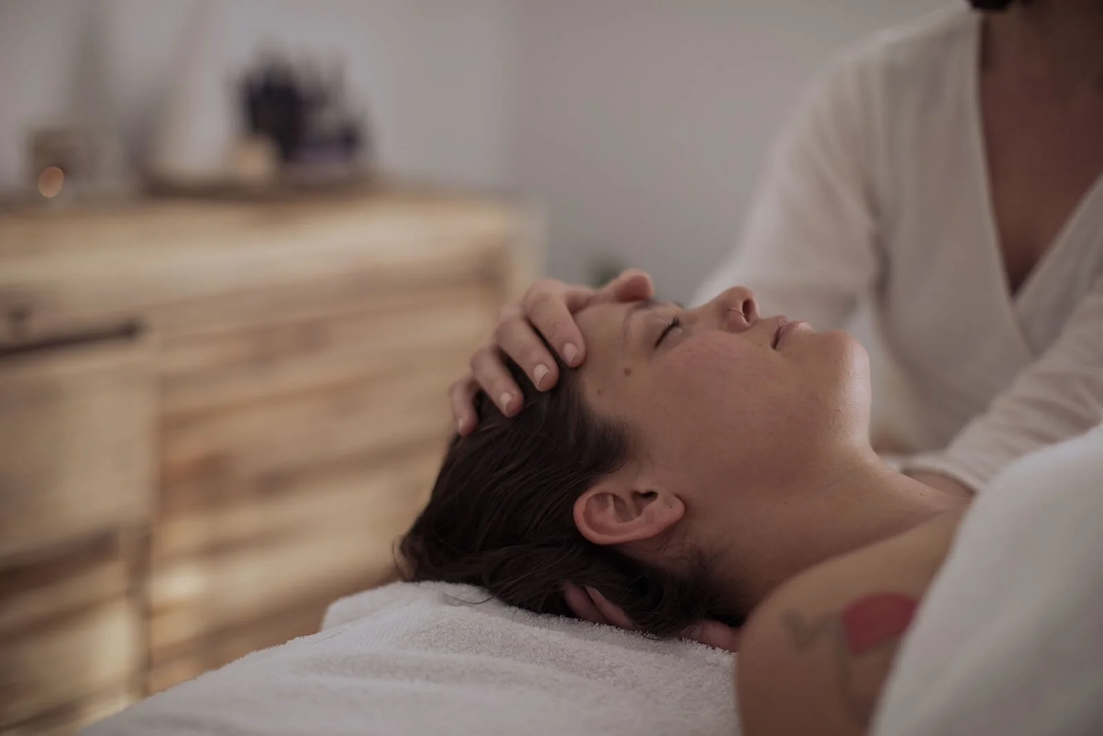 A woman receiving a craniosacral therapy while lying on a massage table in Ocean Shores.