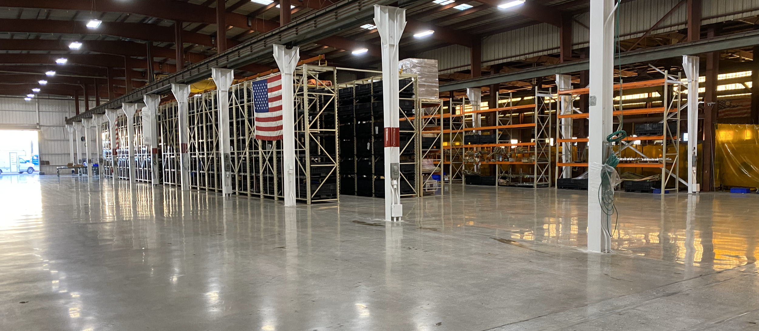 Completed warehouse flooring installation showing professional epoxy coating  system applied to manufacturing facility concrete floor with minimal downtime and professional finishing.