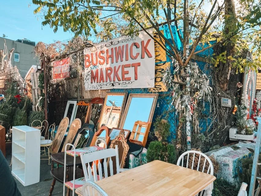 Bushwick Market outdoor yard sale in Brooklyn with furniture, mirrors, and street art.