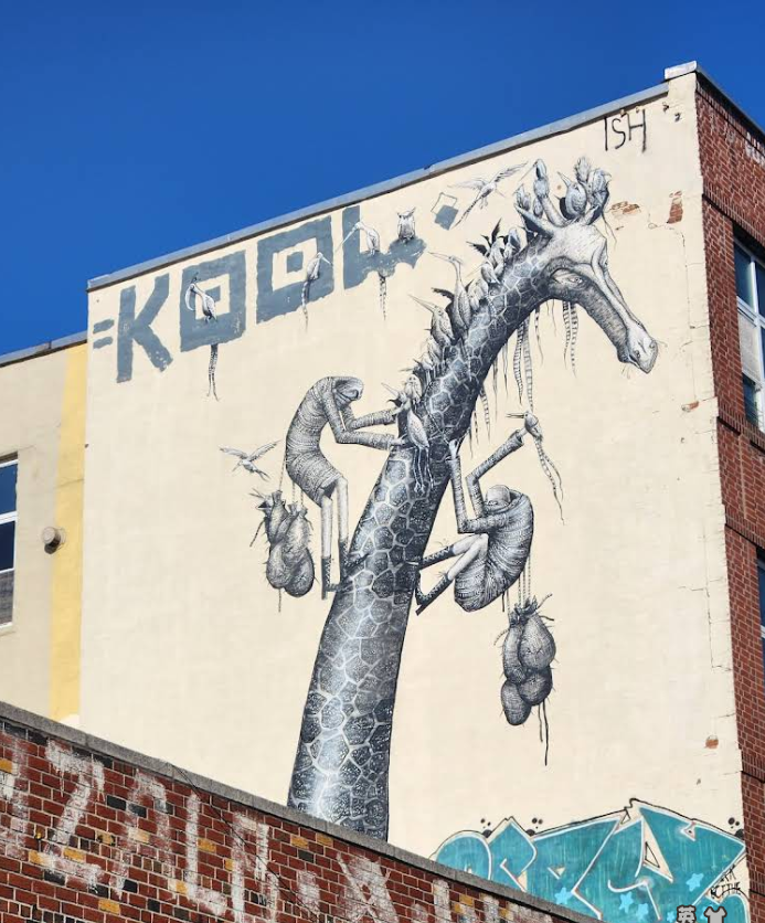 Colorful giraffe street mural with plants and insects on building wall in Bushwick Brooklyn.