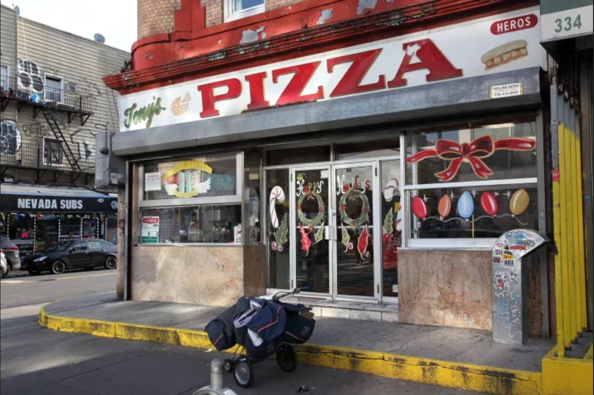 Exterior of Tony’s Pizzeria in Bushwick Brooklyn with holiday decorations.