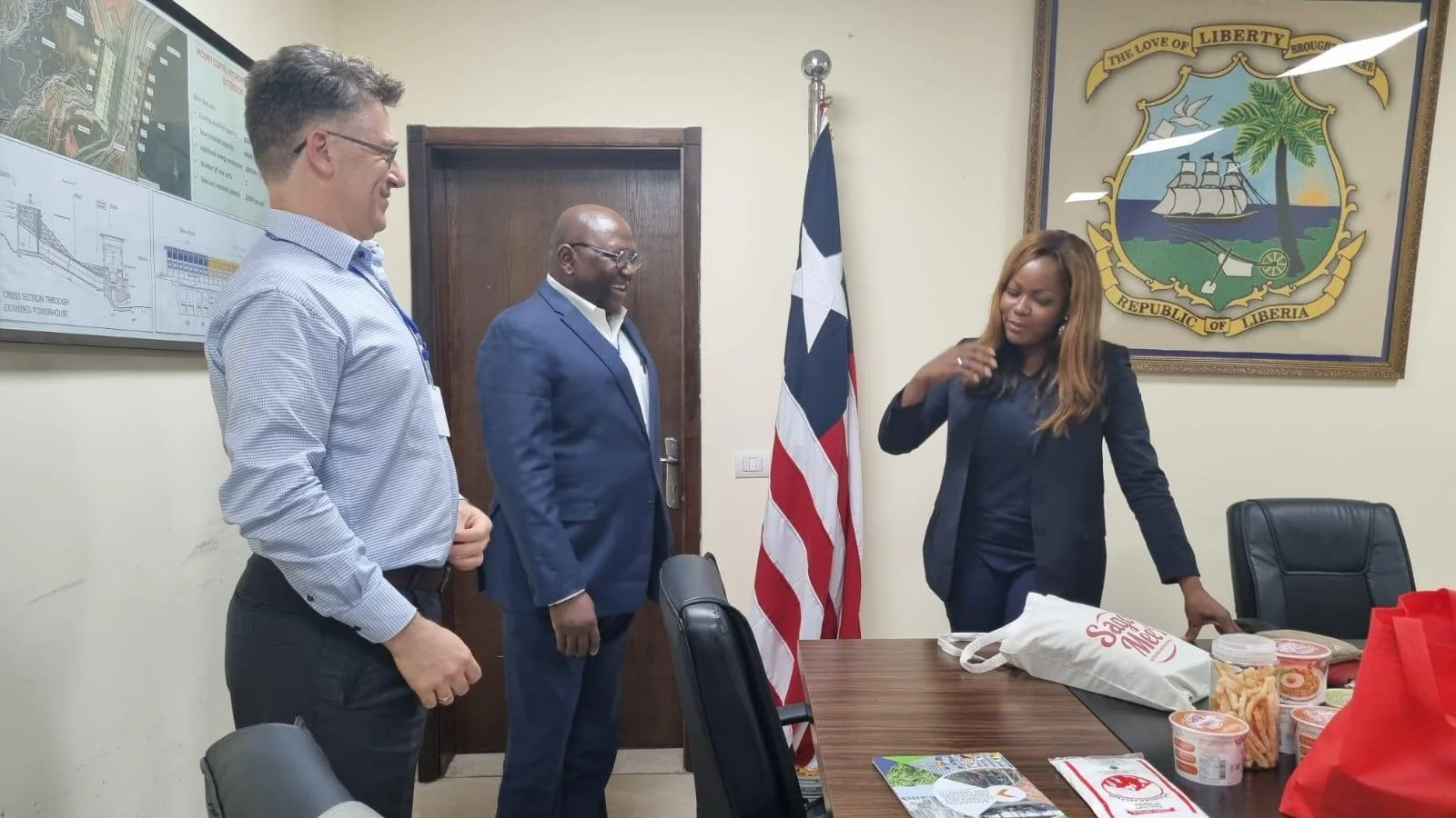 Food science expert Dr. Tony Bello smiling during a meeting with a government official in the Office of the Republic of Liberia