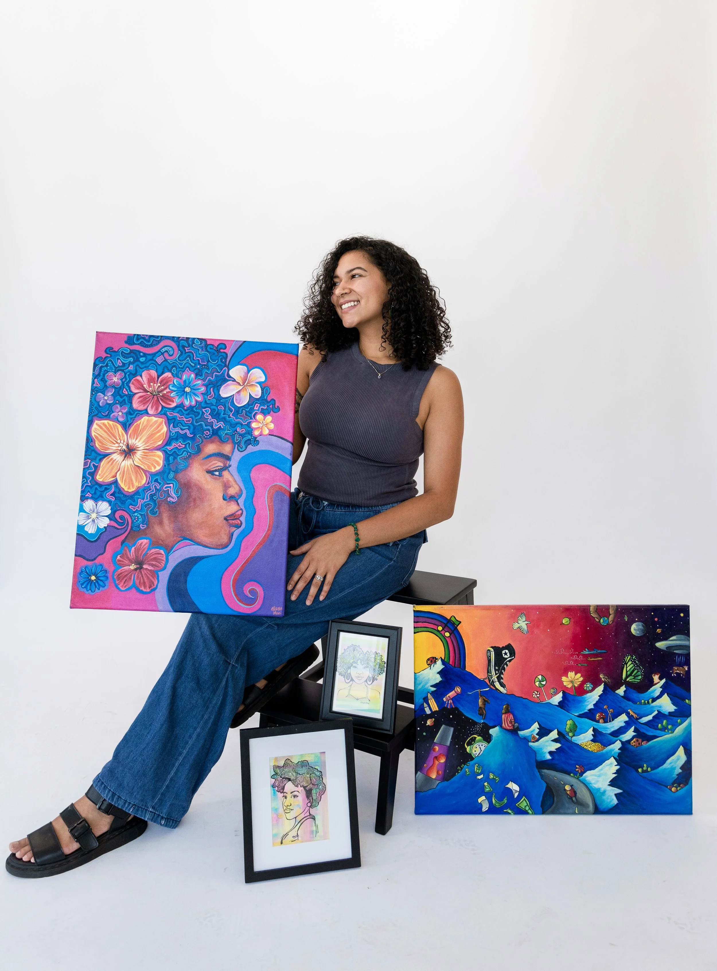 Artist posing with her vibrant paintings at No Bounds Studio in Denver Colorado