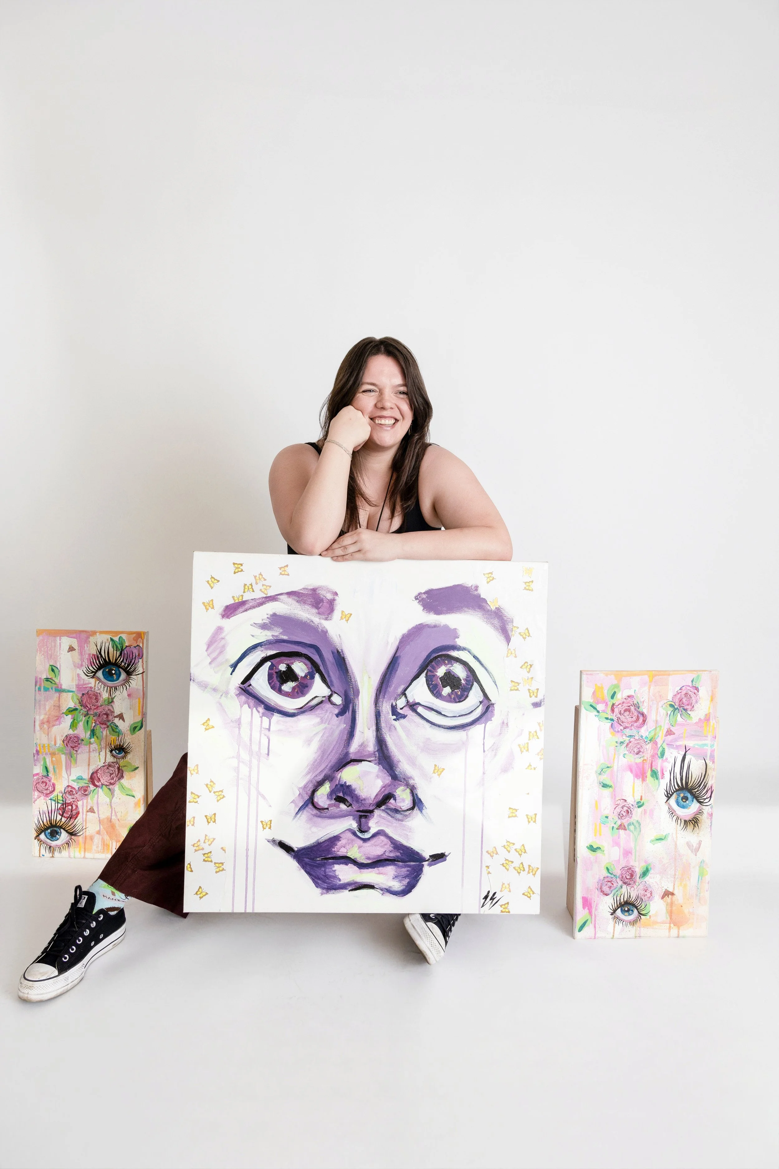 Artist surrounded by her work and smiling at No Bounds studio in Denver Colorado
