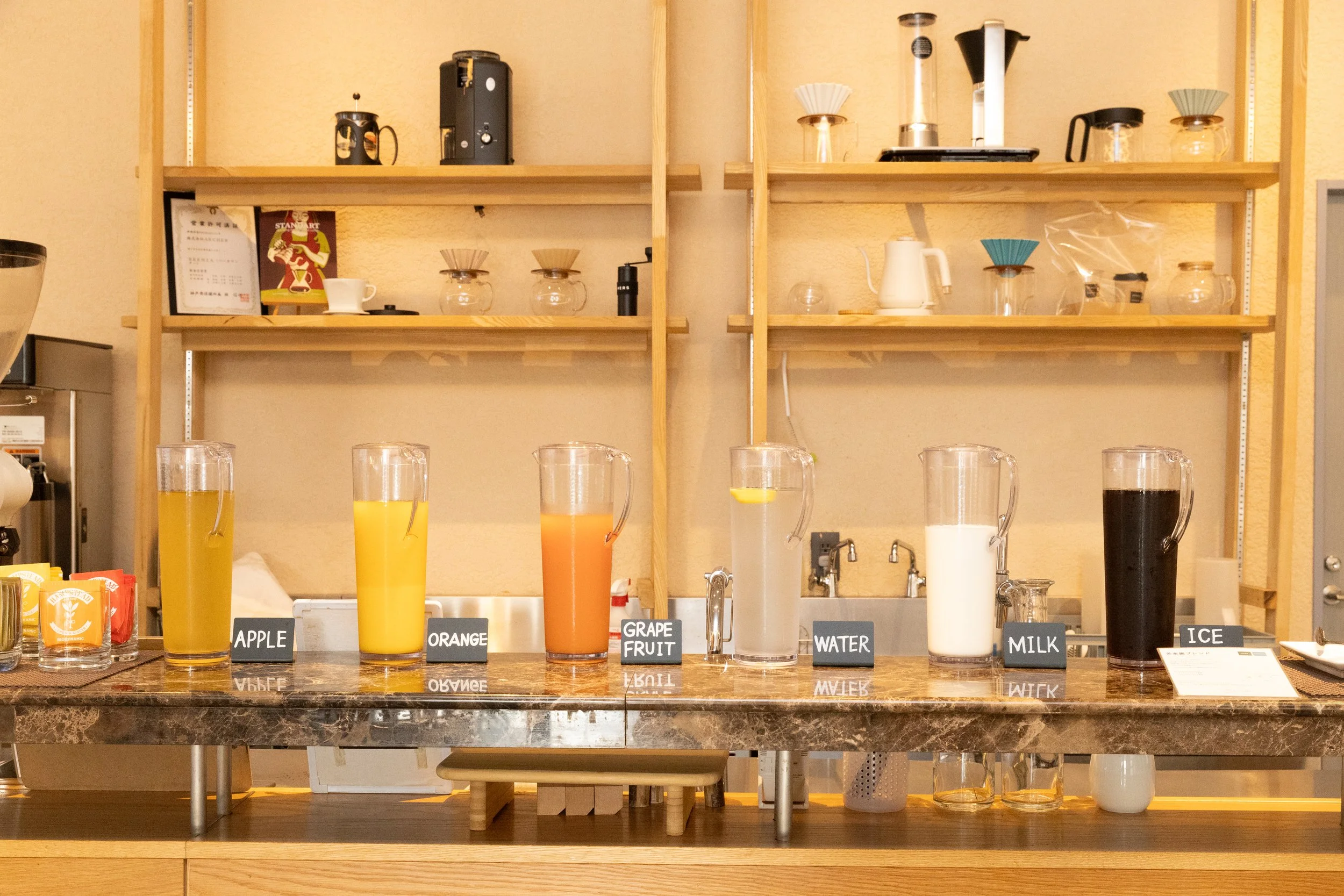 カウンターに並んださまざまな種類の飲み物と小さな黒い板に名前が書かれている。