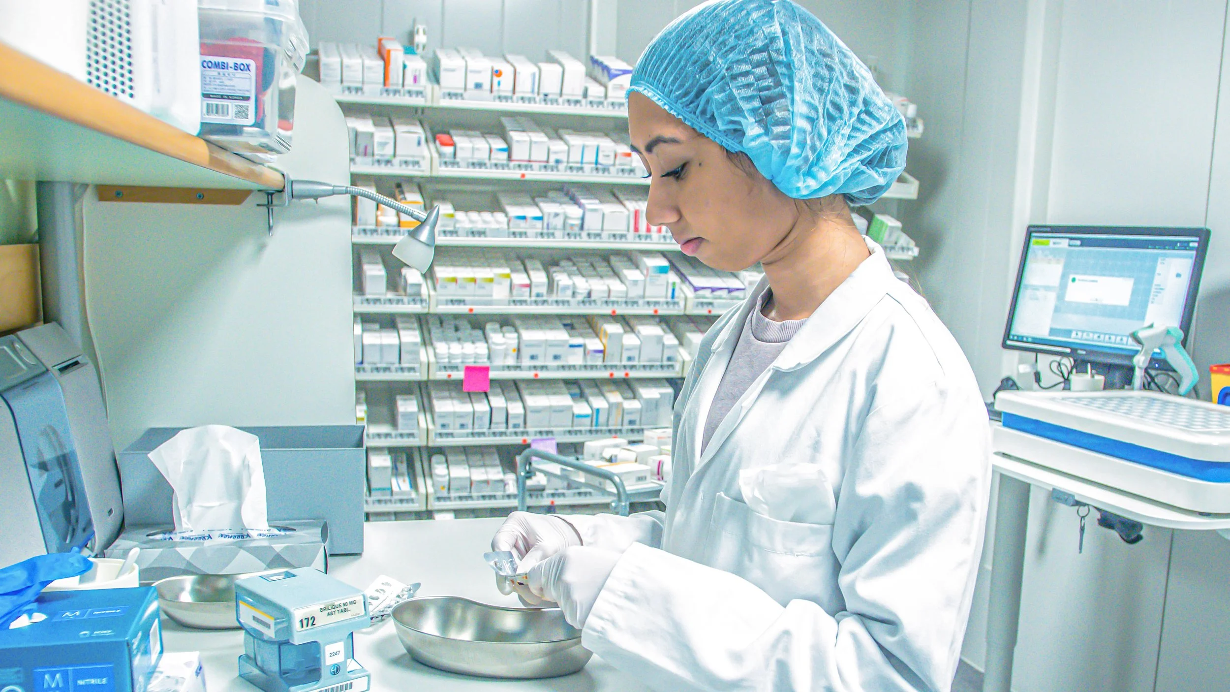Kvinnlig farmaceut på Medovia hanterar läkemedel i skyddsutrustning