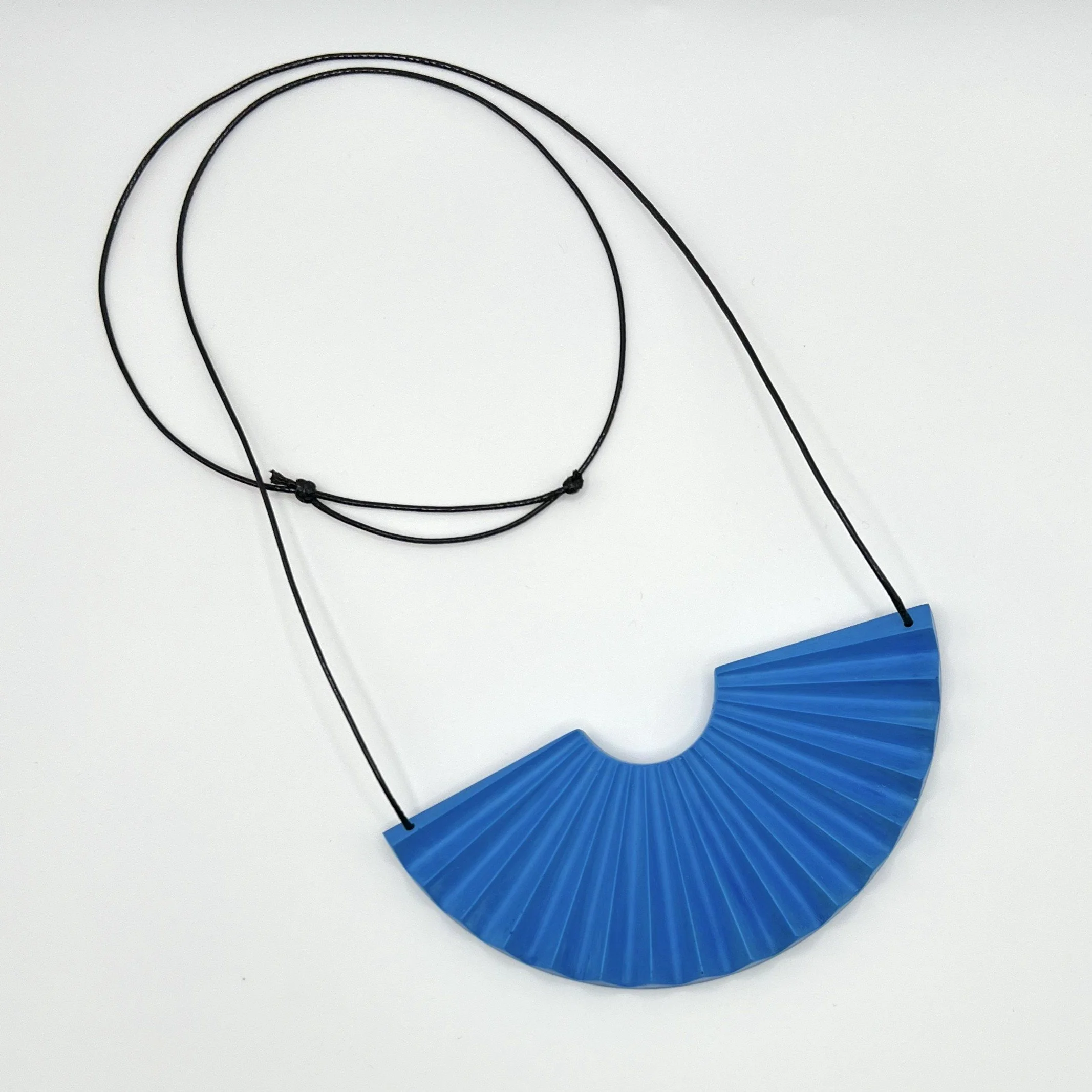 blue jesmonite fan shaped statement necklace with adjustable black cord on white background