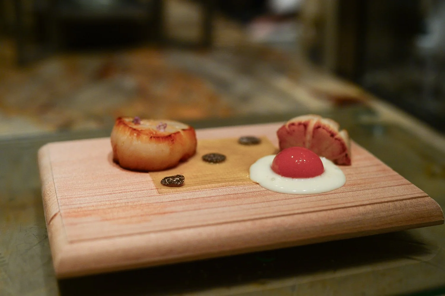 Scallops from Hokaido on corn paper truffle dots and a fried egg made out of bechamel sauce for the white and bell pepper puré for the yolk. 