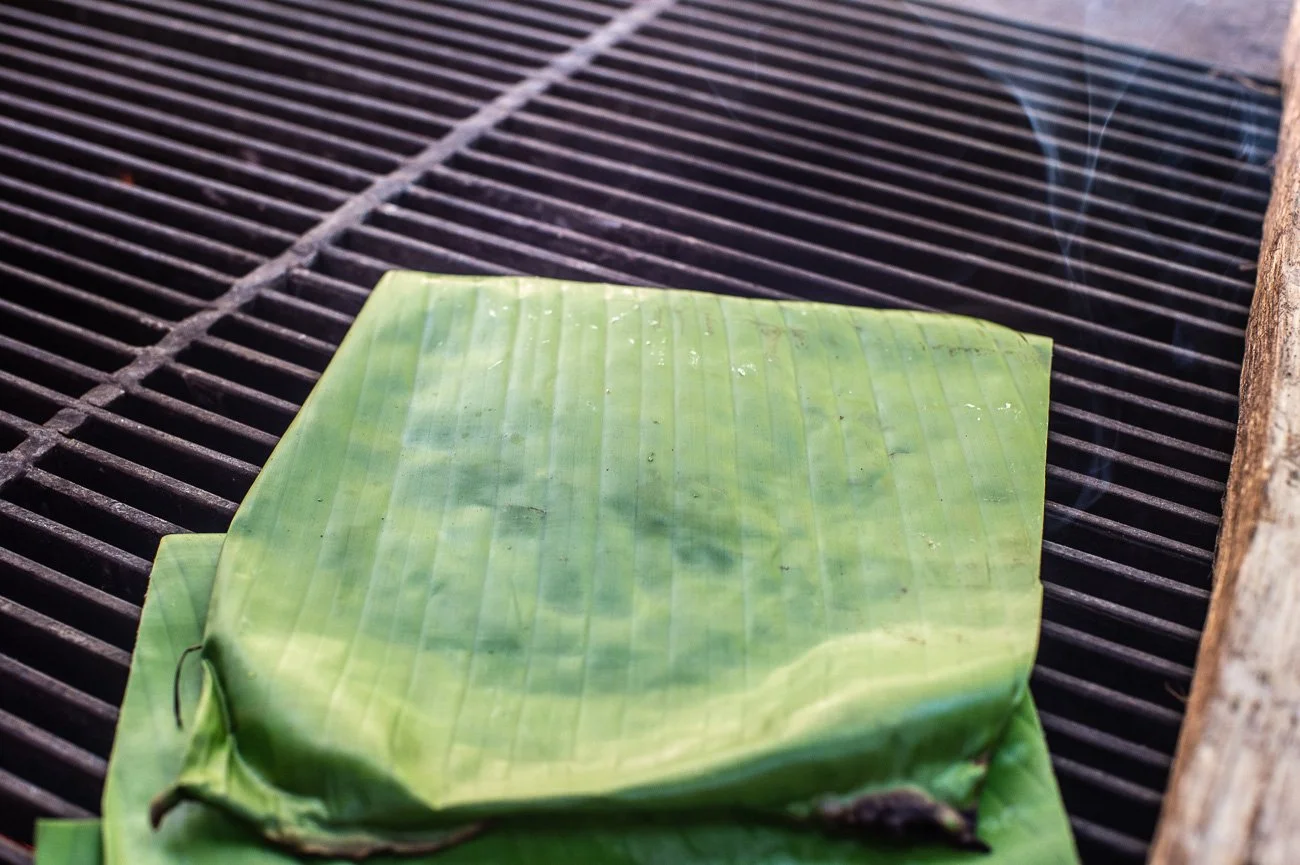  3. Banana leaves are passed over heat over a grill  