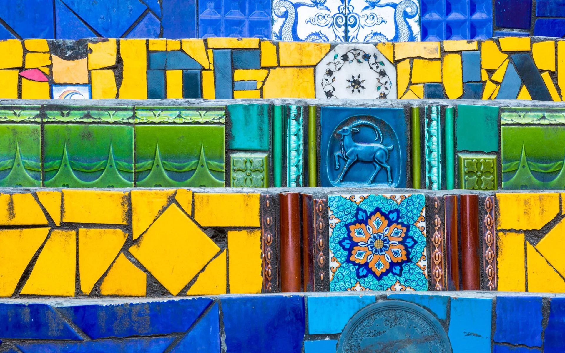 Close-up view of the Selarón Steps featuring green, blue, and yellow ceramic tiles arranged in Brazil’s national colors, highlighting the intricate and symbolic mosaic design.