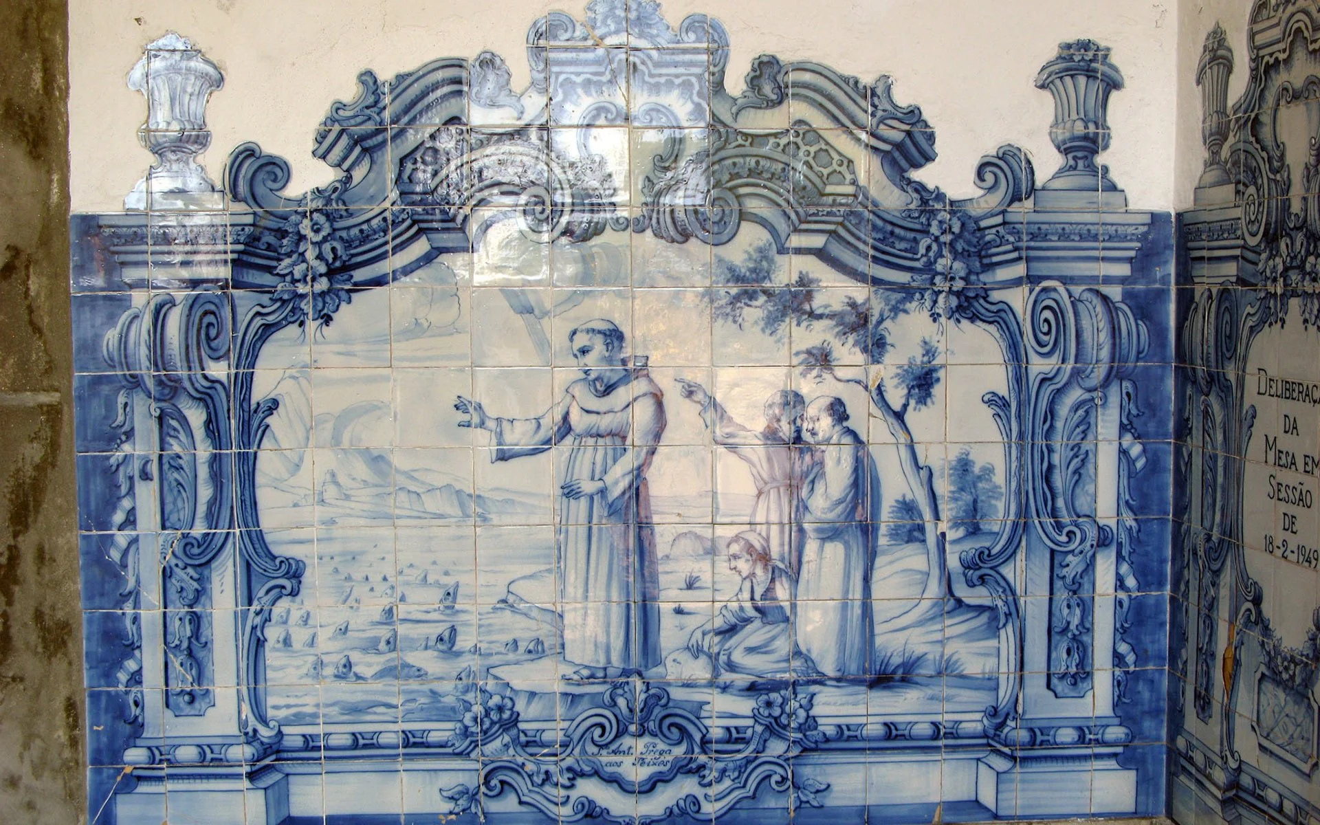 Azulejo tile panel illustrating Saint Anthony preaching to fish, with detailed blue-and-white figures gathered near a coastal scene.