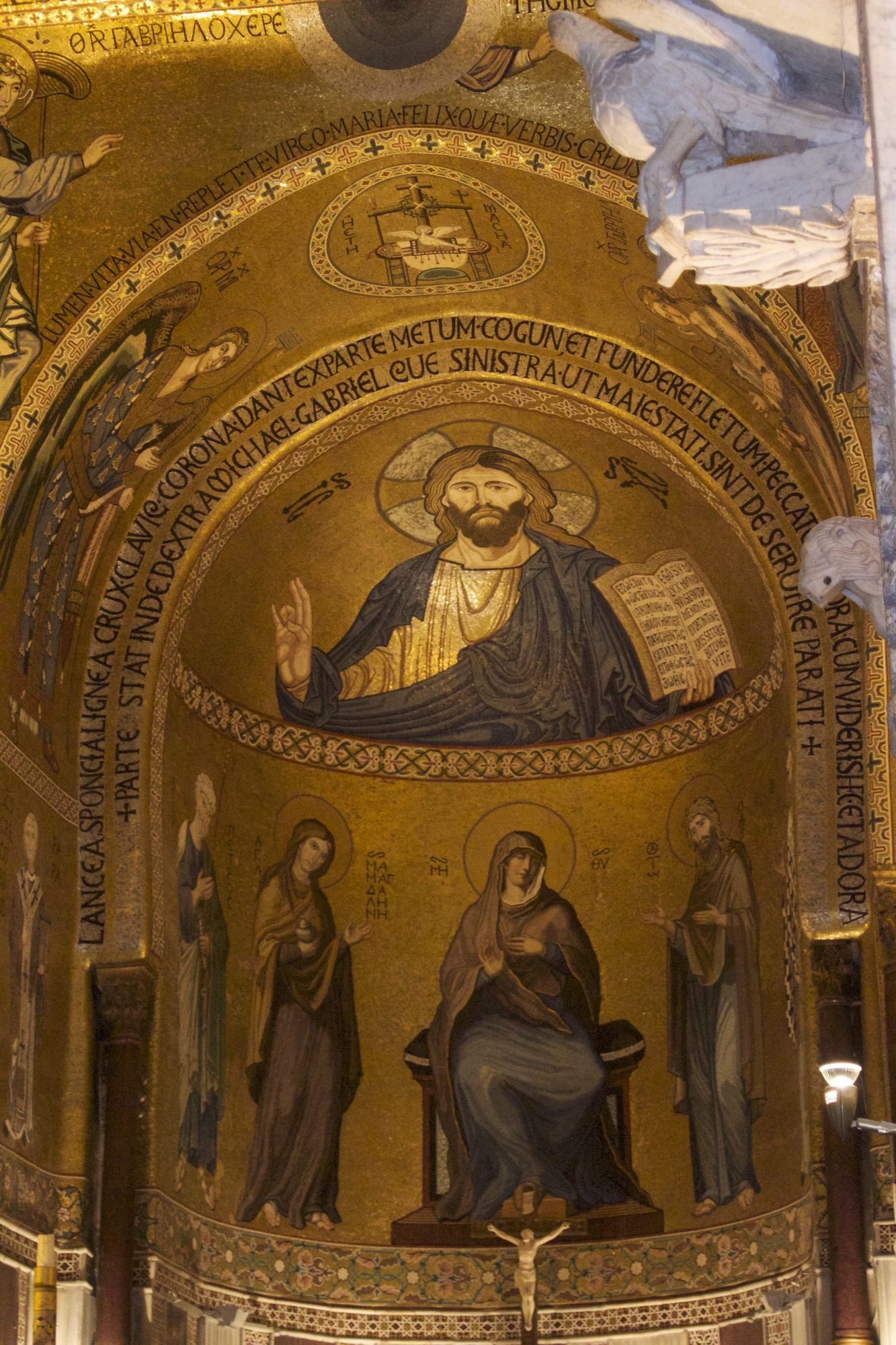Apse of a Norman chapel with a gold mosaic of Christ Pantocrator above saints