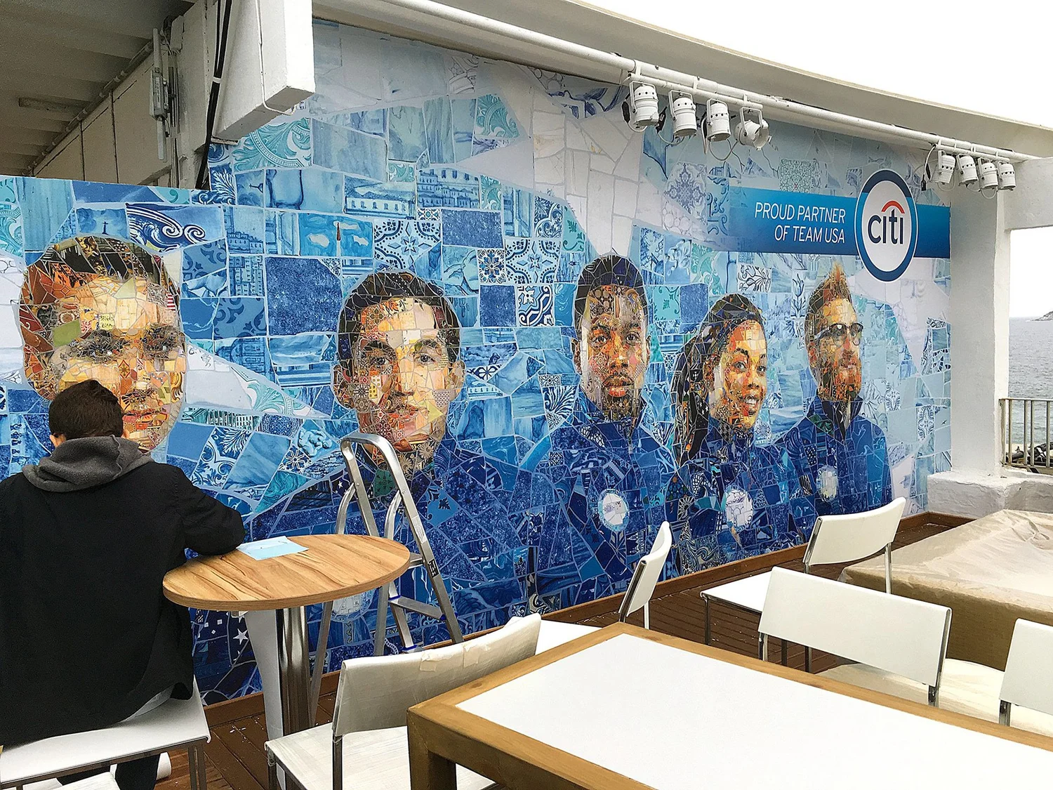 The USA House mural installed in a lounge in Rio de Janeiro, with guests at a table