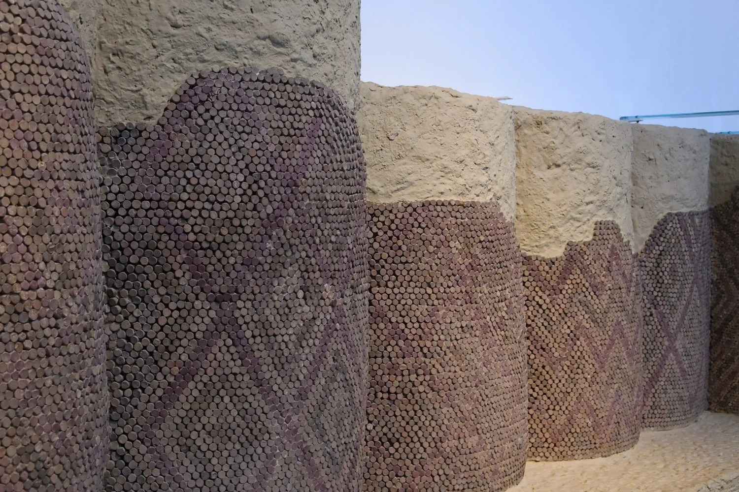 Columns covered in thousands of clay cones whose painted ends form zigzag and lozenge patterns