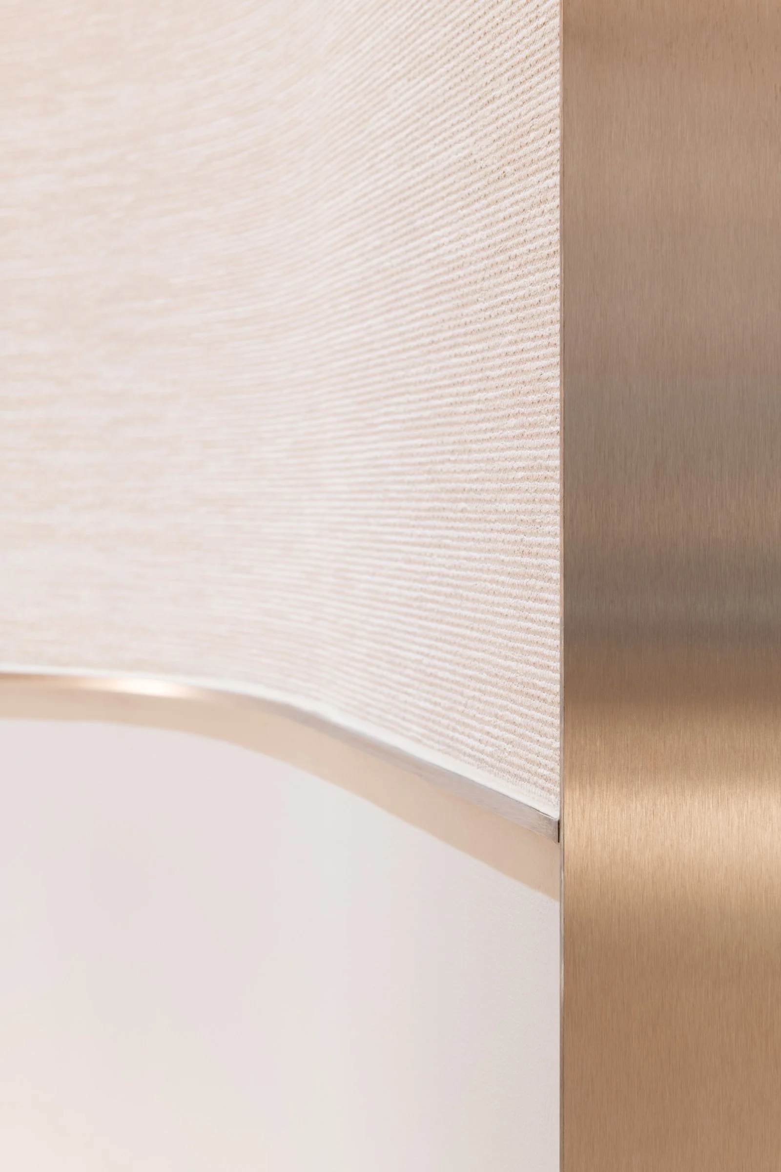 Close-up of a corner wall detail with textured fabric and metal.