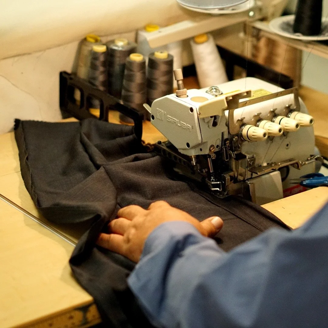 Person sewing fabric using industrial sewing machine in workshop.