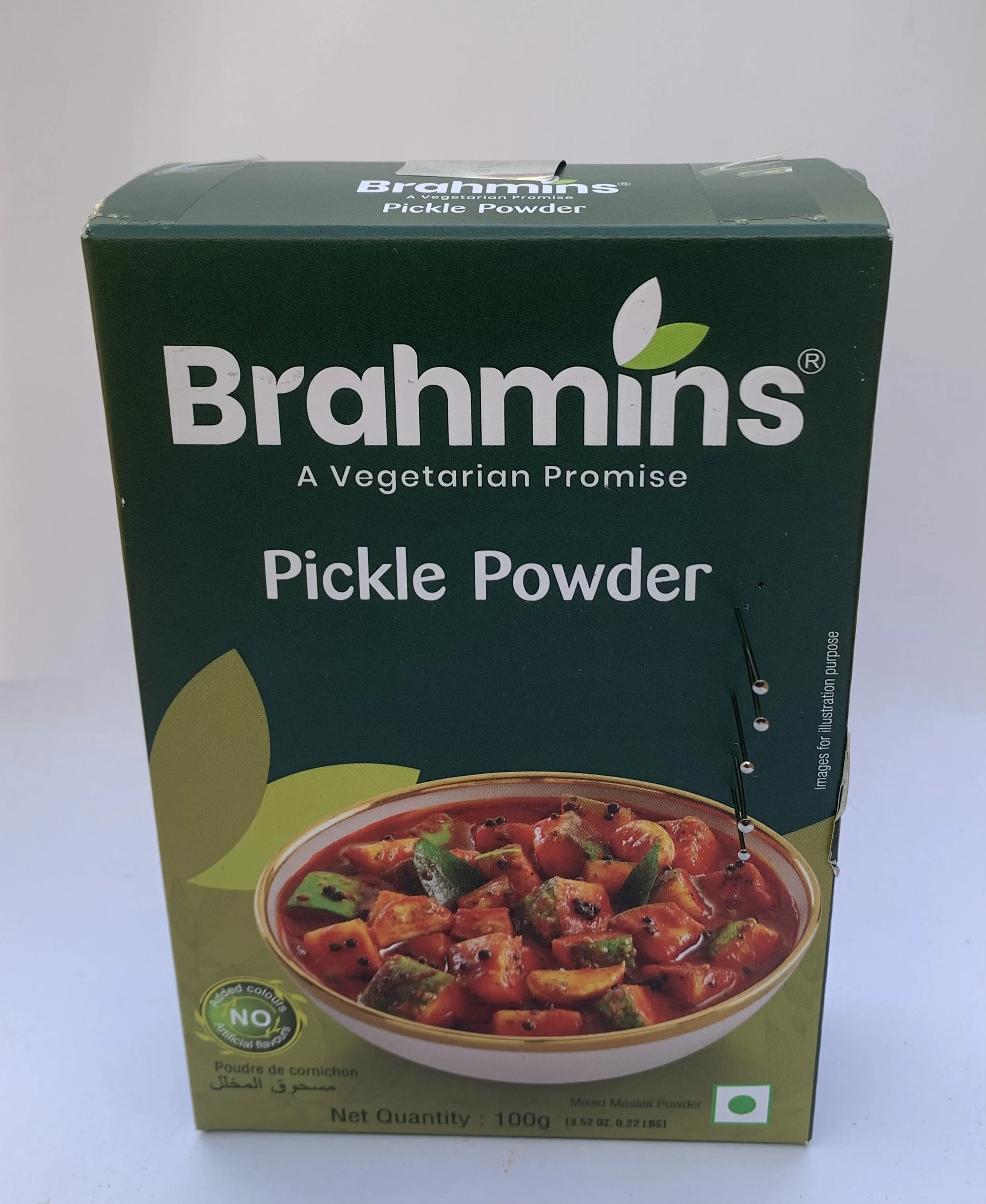 Box of Brahmins pickle powder packaging marked with puncture holes, referencing caste, purity, consumption, and diasporic branding.