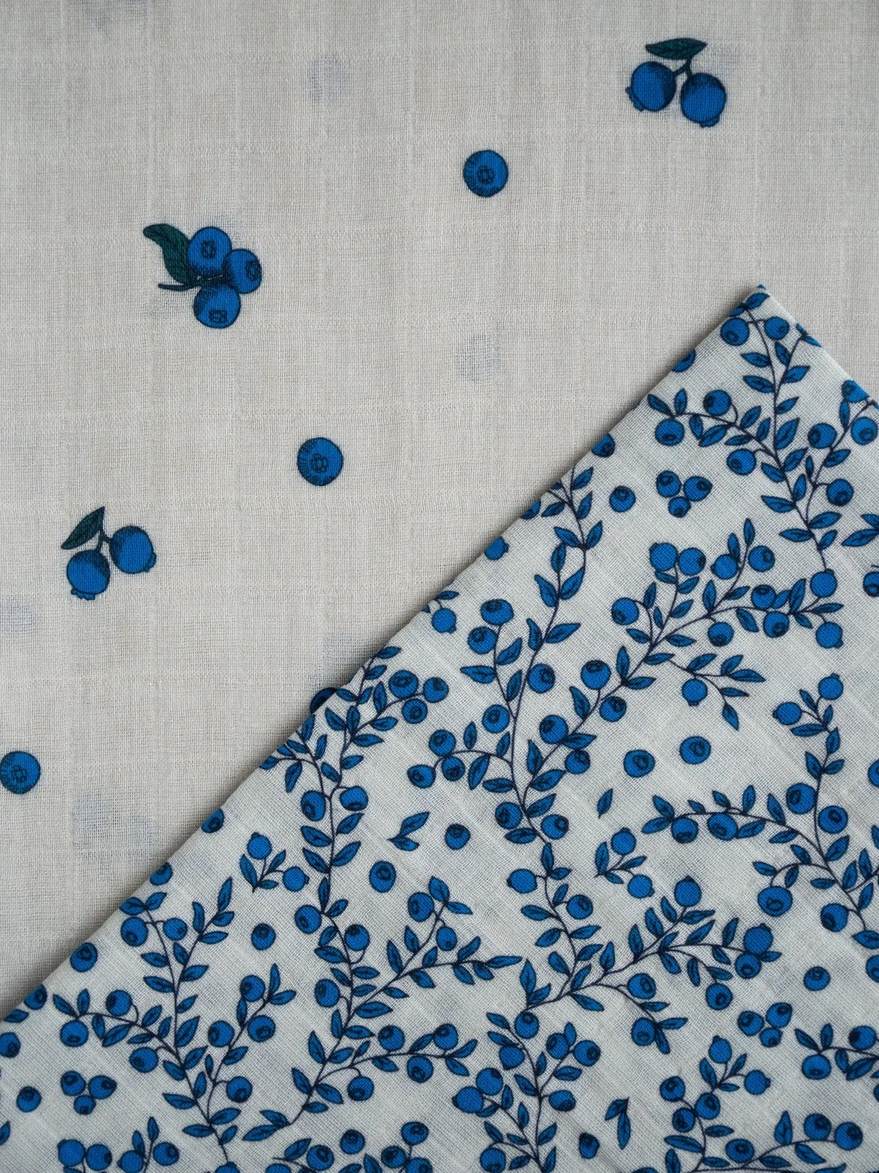 Illustrated handdrawn blueberry  pattern on white background and blueberry and leaf pattern on white fabric for baby essentials