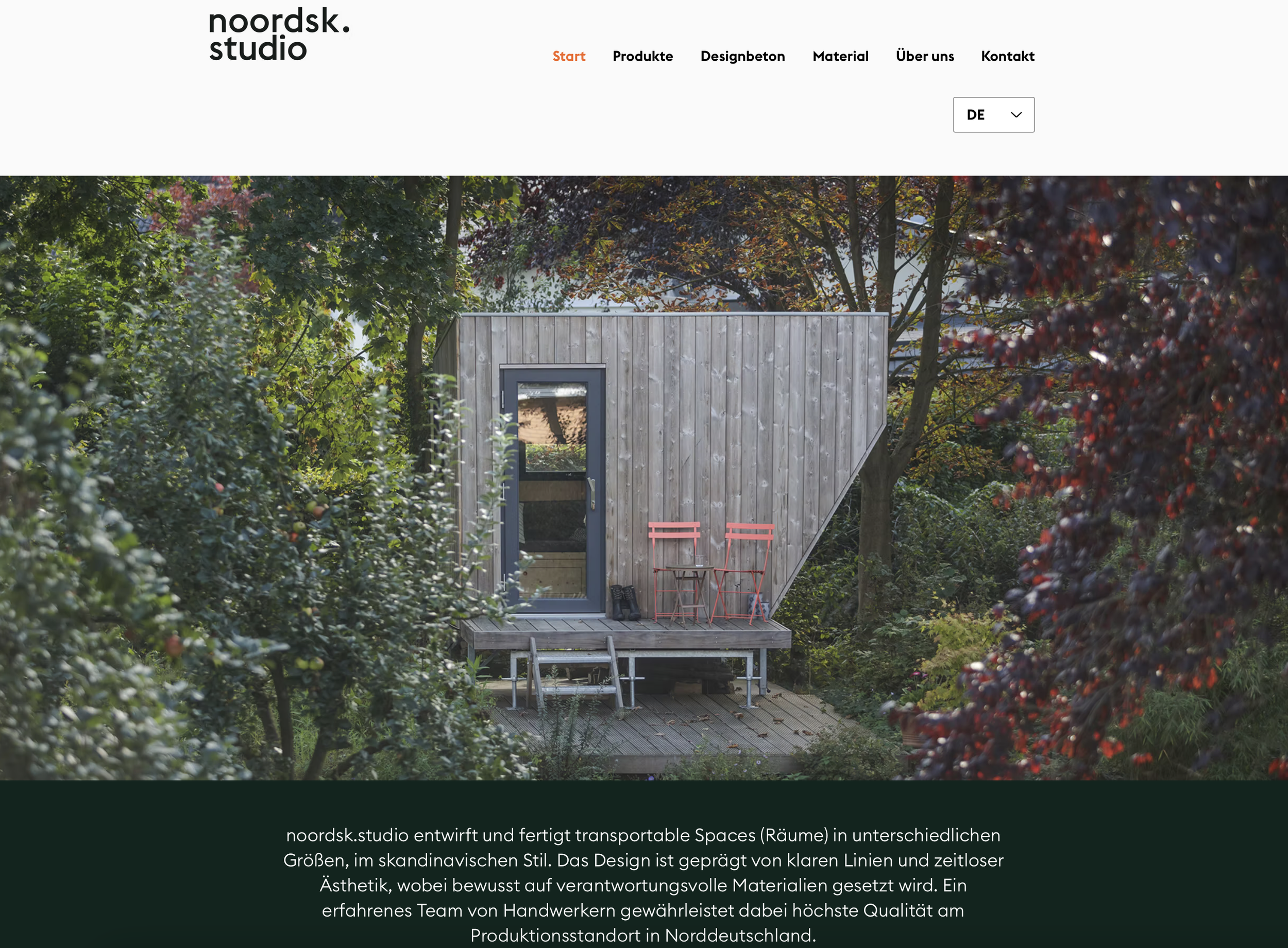 Compact modern wooden tiny house with outdoor seating, surrounded by trees.